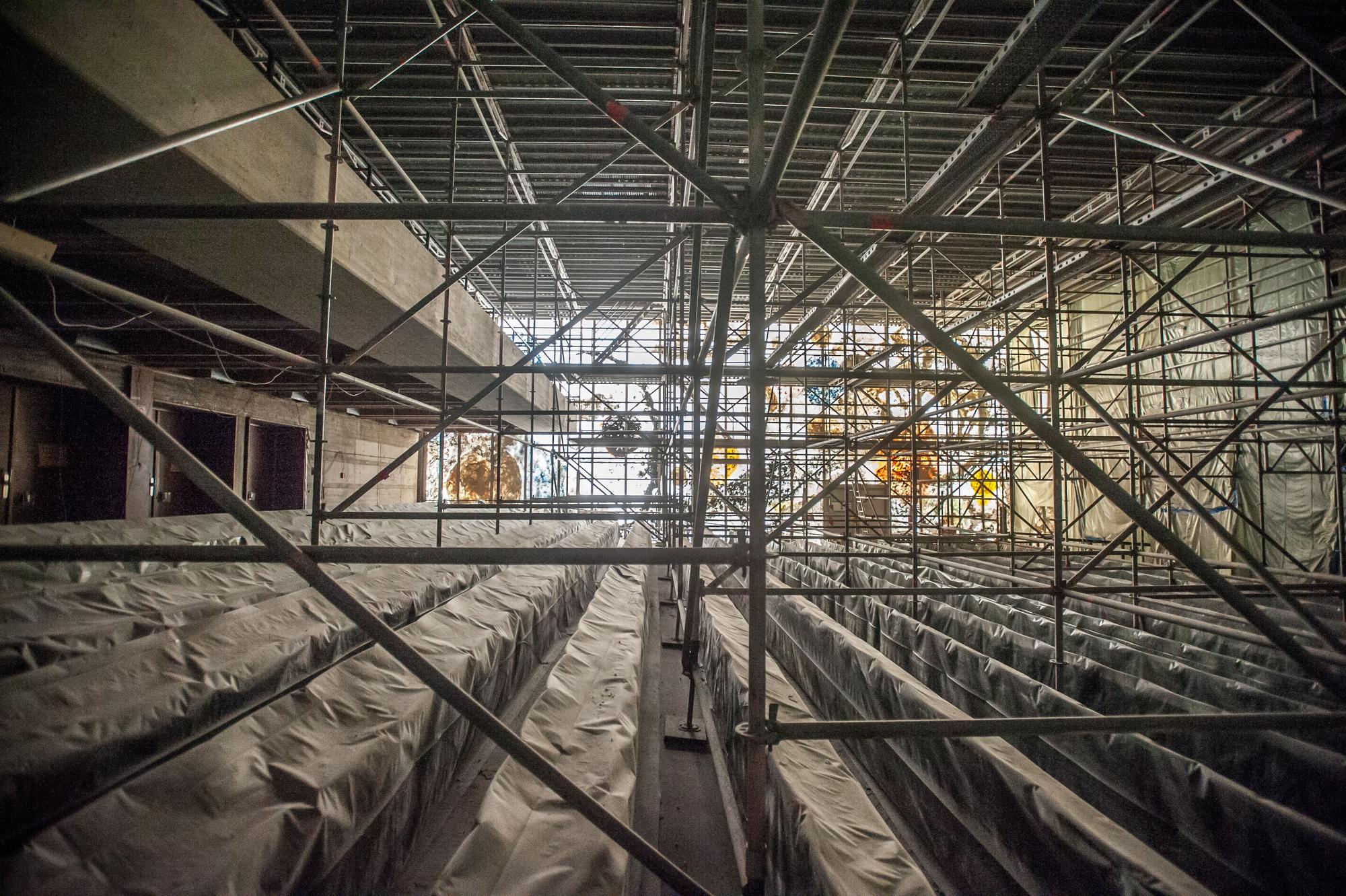 In der Aula steht ein Baugerüst, Stühle sind abgedeckt.