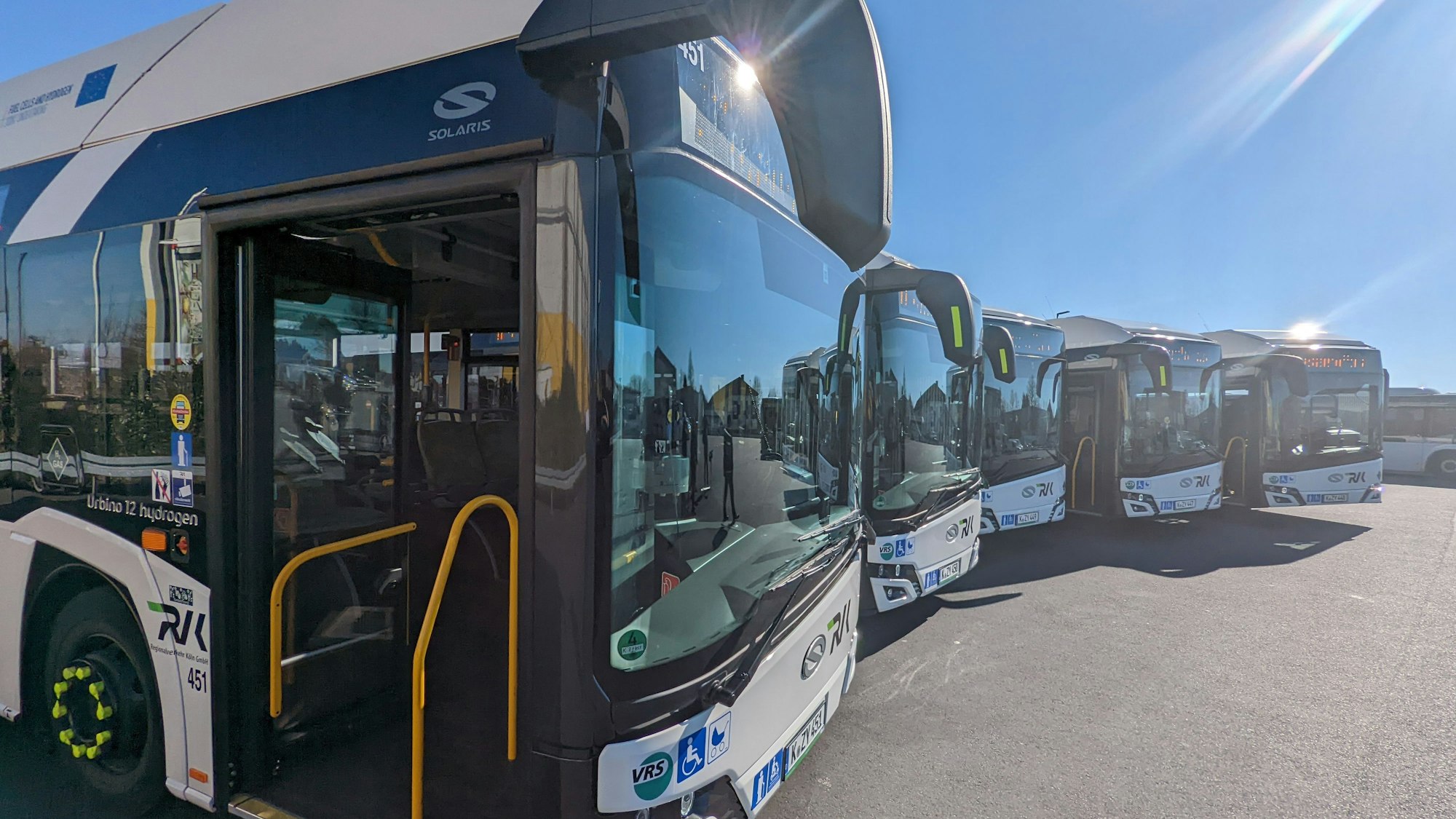 Fünf Busse stehen leicht versetzt nebeneinander auf dem Betriebshof.