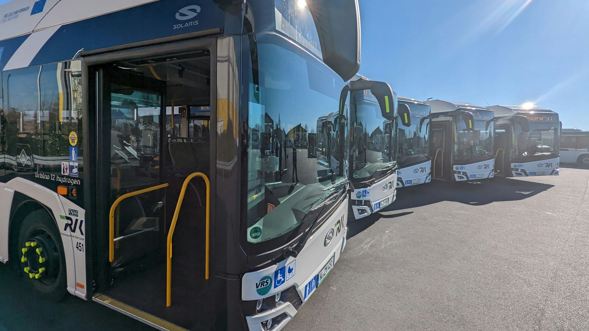 Fünf neue Wasserstoffbusse vom Typ Solaris stehen auf einem Parkplatz.