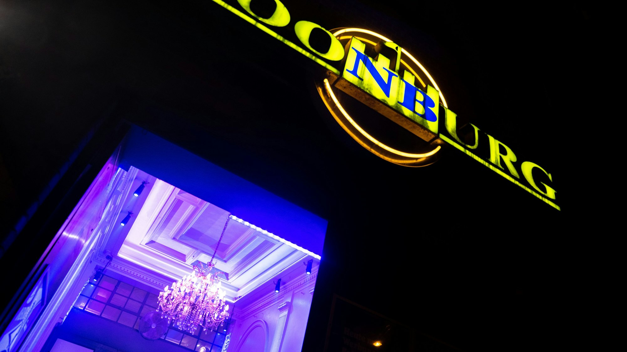 Der Eingang vom  Club Roonburg leuchtet in der Nacht.