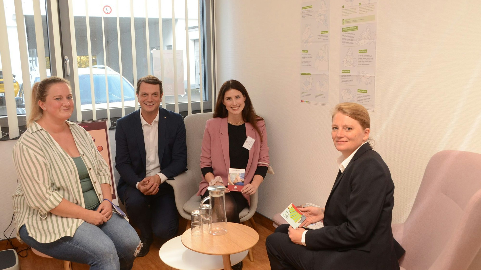 Hebamme Melanie Baumgart, Landtagsabgeordneter Björn Franken, Projektmitarbeiterin Cornelia Berghs und Windecks Bürgermeisterin sitzen im Untersuchungsraum.