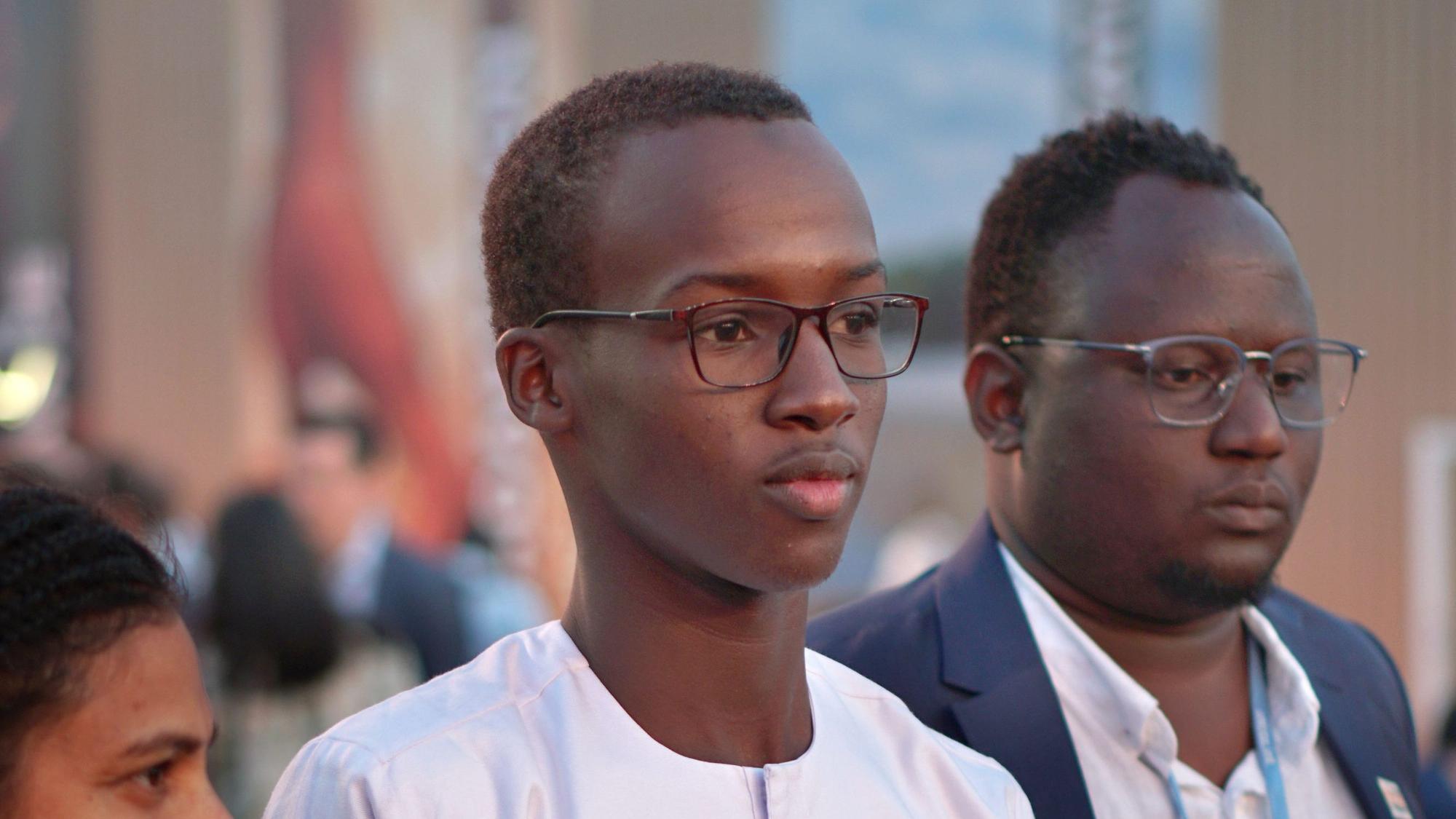 Yero Sarr steht mit anderen Aktivistinnen und Aktivisten auf der Cop27.