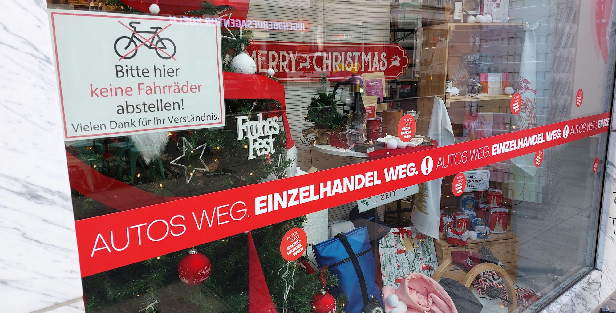 An einem Schaufenster auf der Deutzer Freiheit liest man „Autos weg, Einzelhandel weg“.