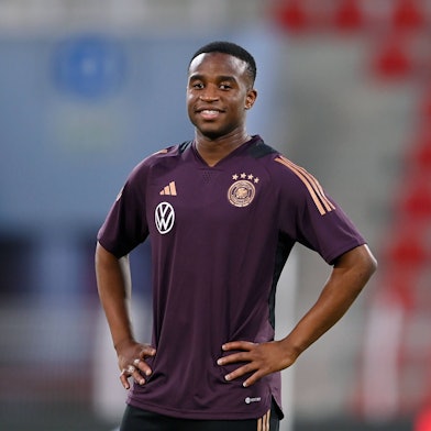 Youssoufa Moukoko steht mit verschränkten Armen auf dem Trainingsplatz beim Abschlusstraining der deutschen Nationalmannschaft vor dem Testspiel gegen Oman.