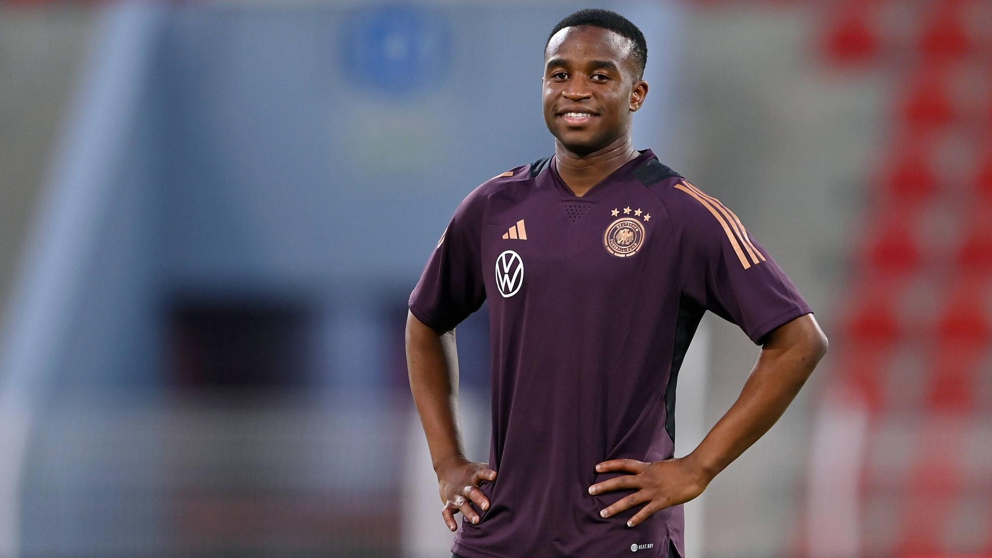 Youssoufa Moukoko steht mit verschränkten Armen auf dem Trainingsplatz beim Abschlusstraining der deutschen Nationalmannschaft vor dem Testspiel gegen Oman.