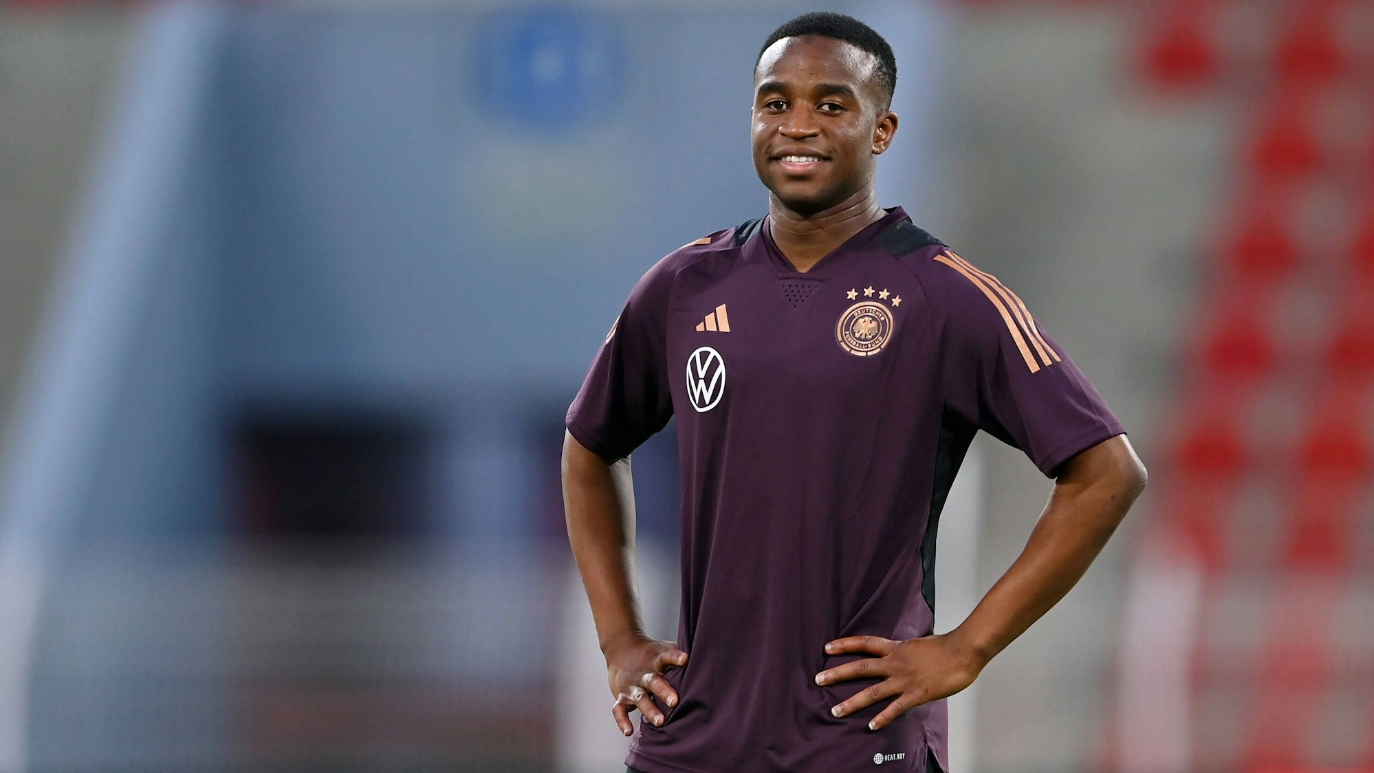 Youssoufa Moukoko steht mit verschränkten Armen auf dem Trainingsplatz beim Abschlusstraining der deutschen Nationalmannschaft vor dem Testspiel gegen Oman.