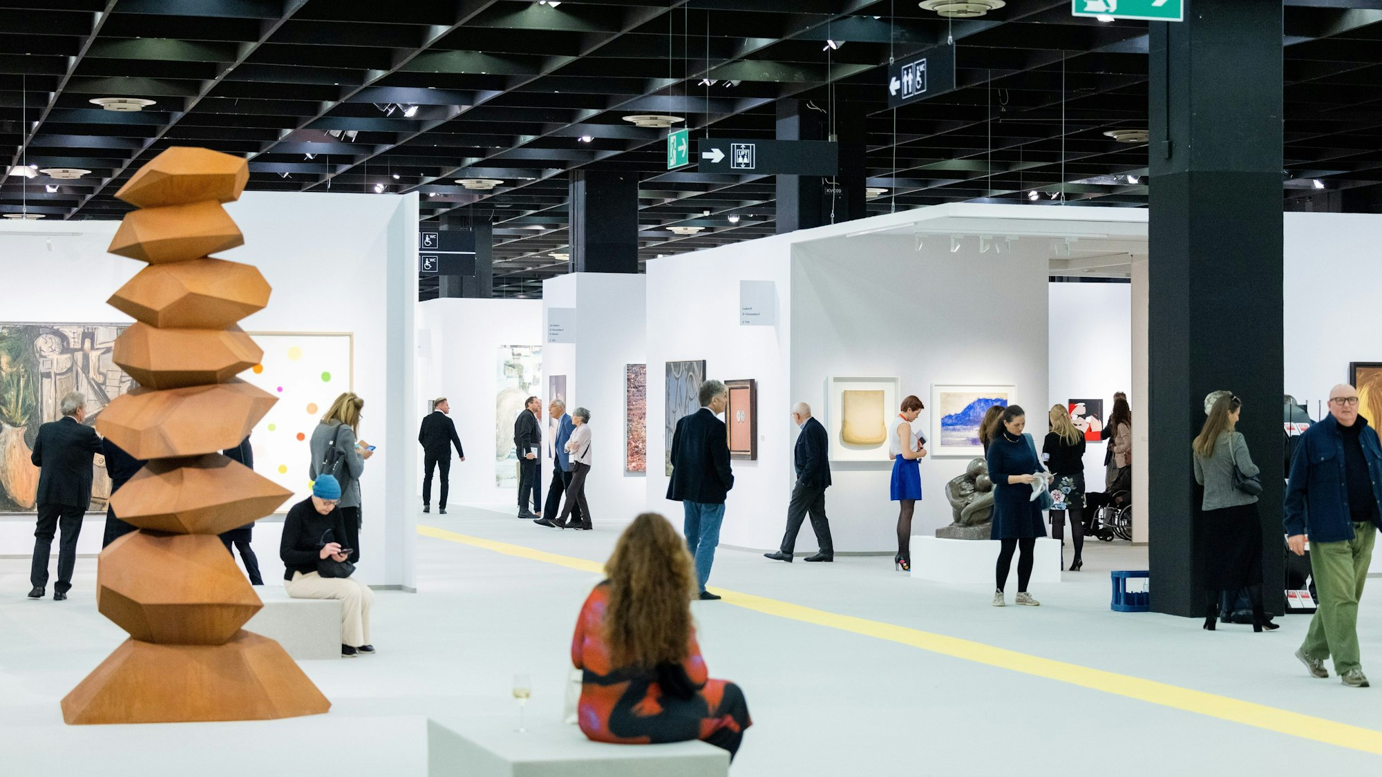 Besucher der Art Cologne gehen durch eine Messehalle der Kunstmesse Art Cologne.