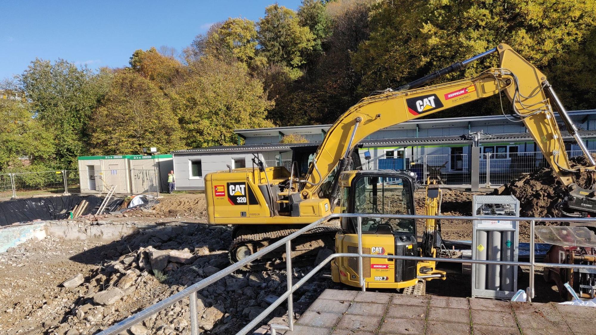 Blick vom abgebrochenen Schwimmeister-Haus Richtung Umkleidetrakt und Kiosk, die stehenbleiben.