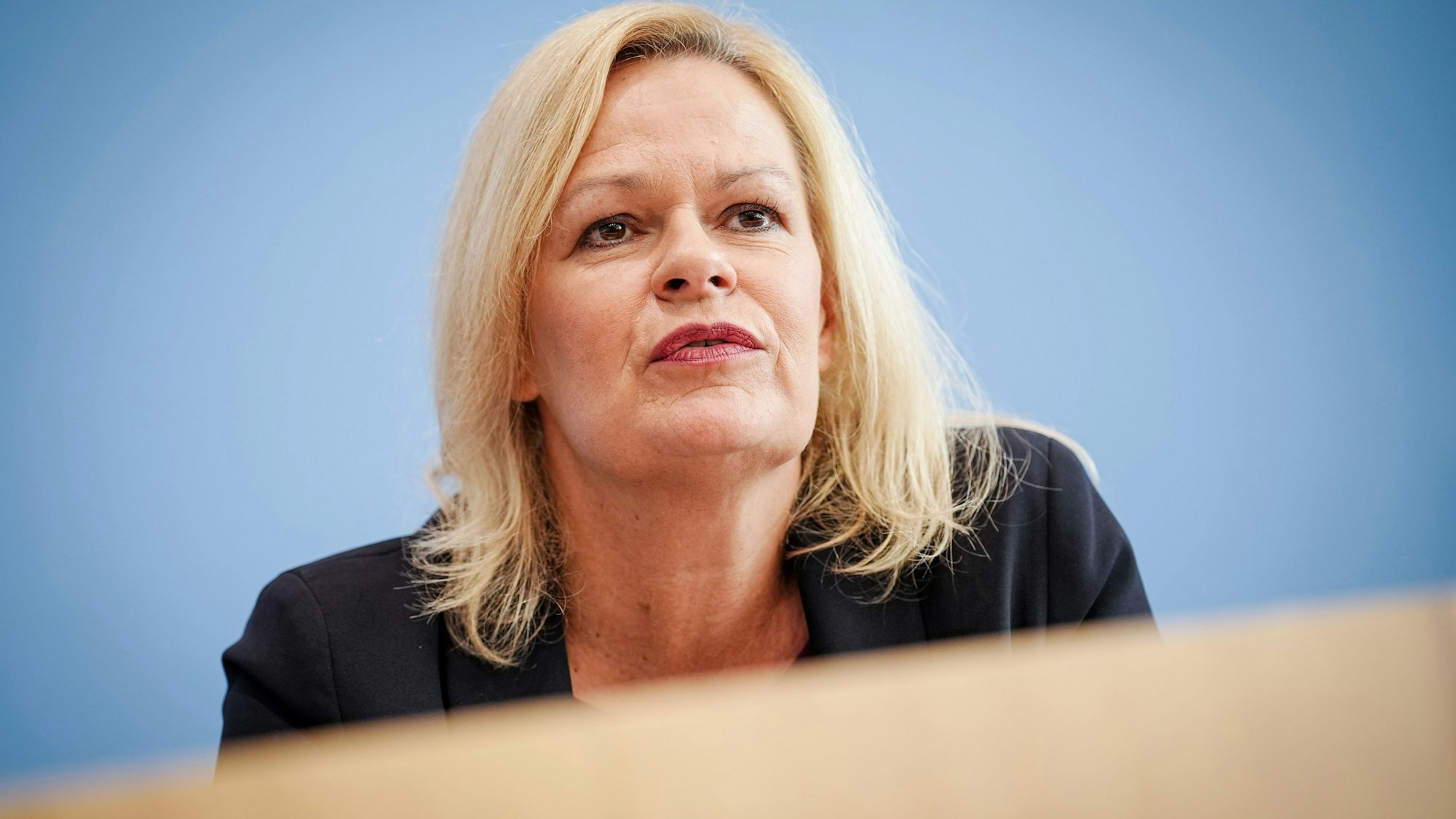 Nancy Faeser (SPD), Bundesministerin für Inneres und Heimat, blickt während einer Pressekonferenz zur Sicherheit und Kriminalität in Deutschland vom Podium.