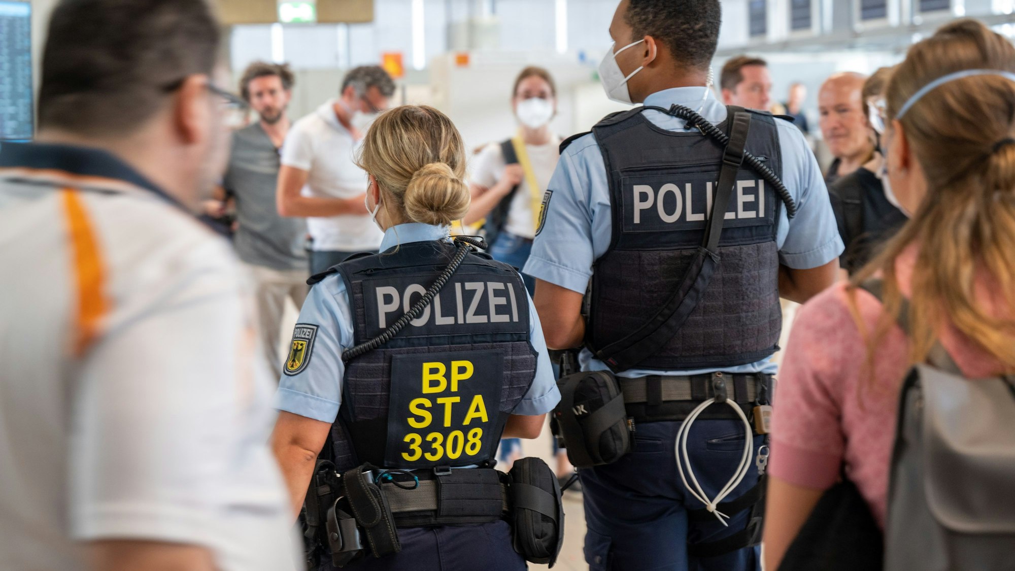 Zwei Bundespolizisten laufen durch den Kölner Flughafen.