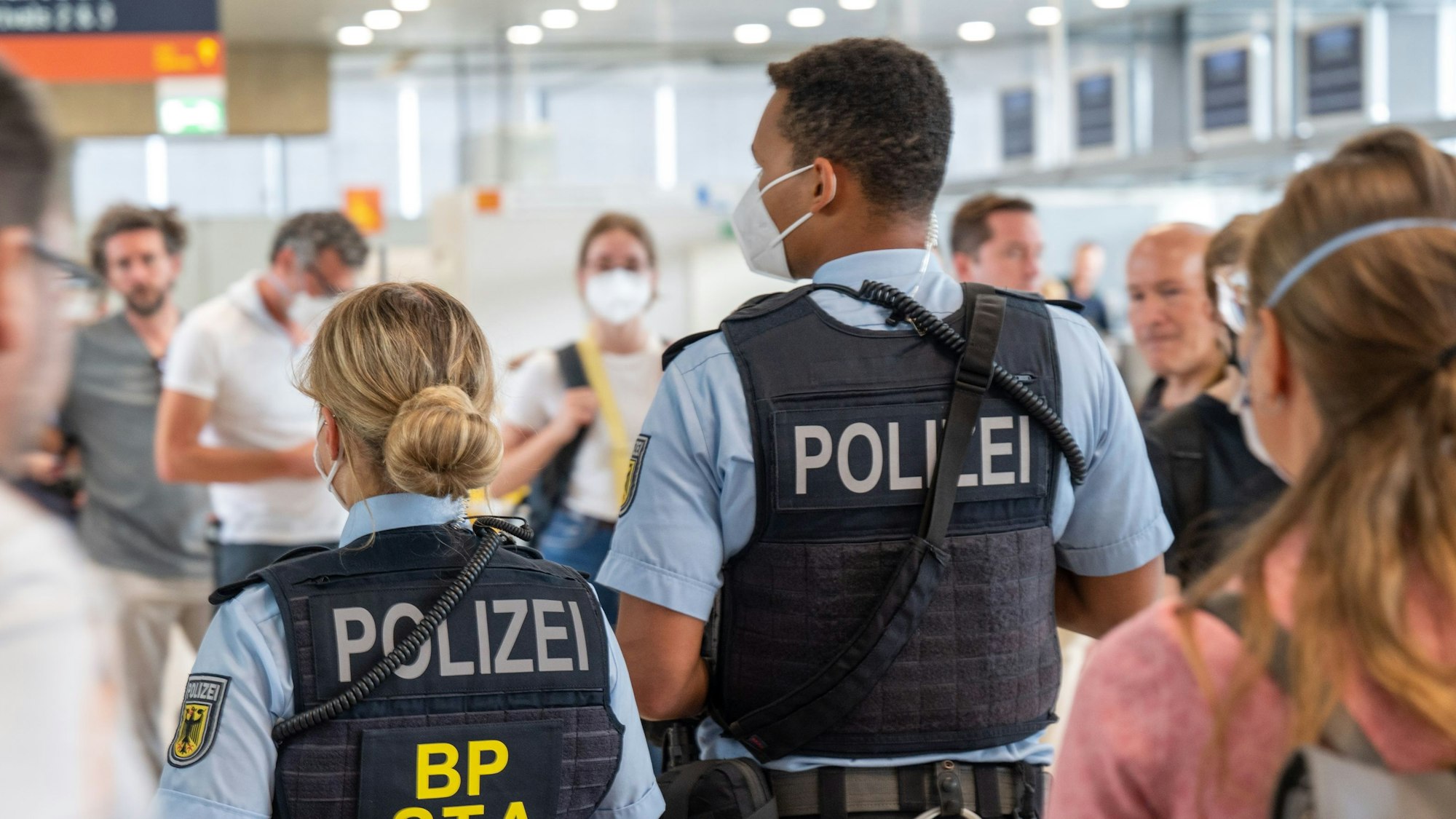 Eine Bundespolizistin und ein Bundespolizist stehen am Gate.