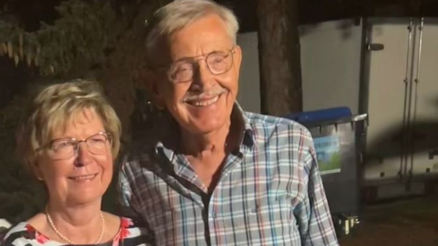 Das Hochzeitspaar lächelt in die Kamera.