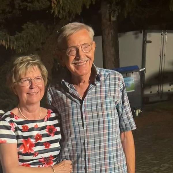 Das Hochzeitspaar lächelt in die Kamera.