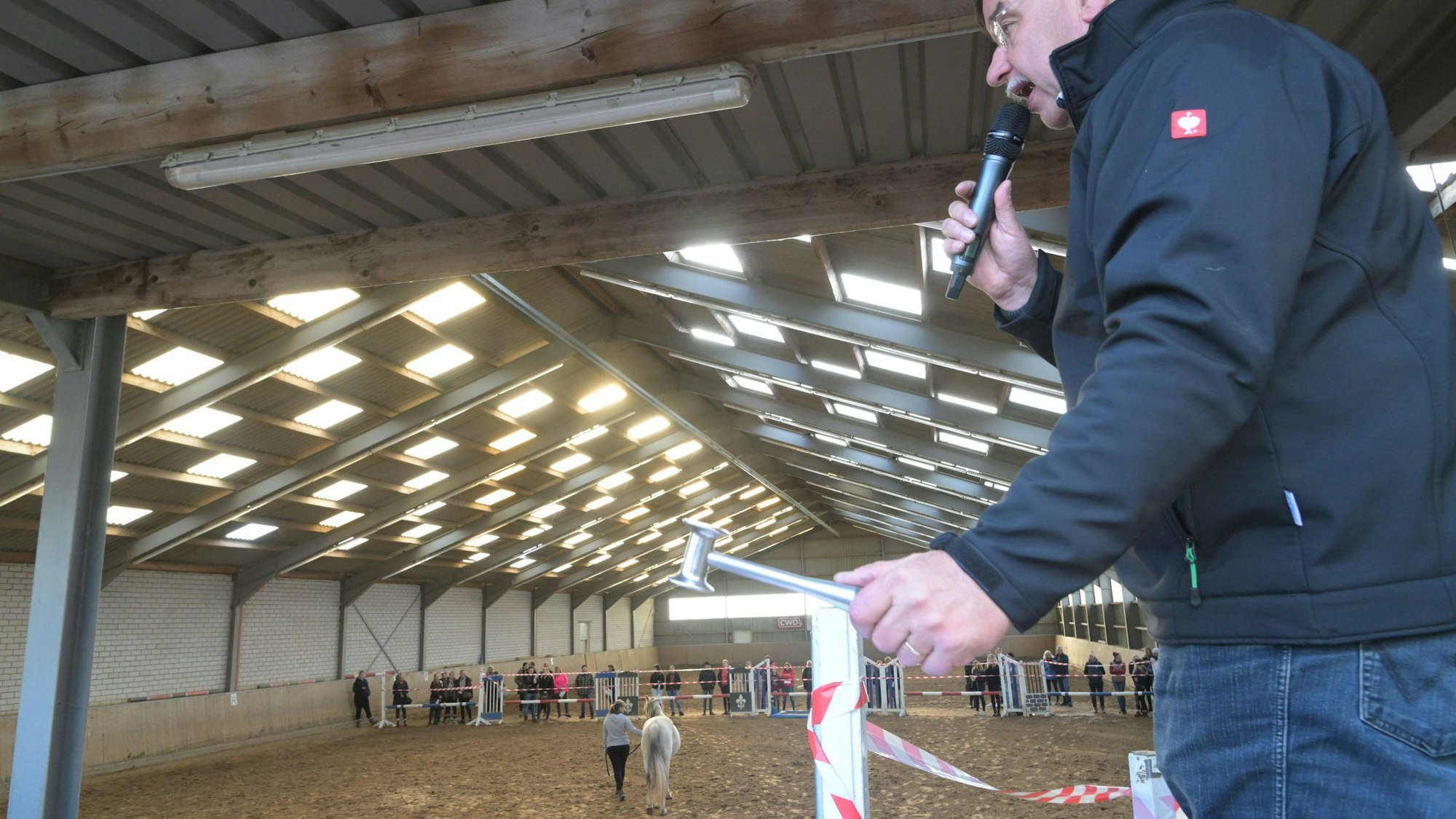 Volker Raulf hat ein Mikro und einen Hammer in der Hand.