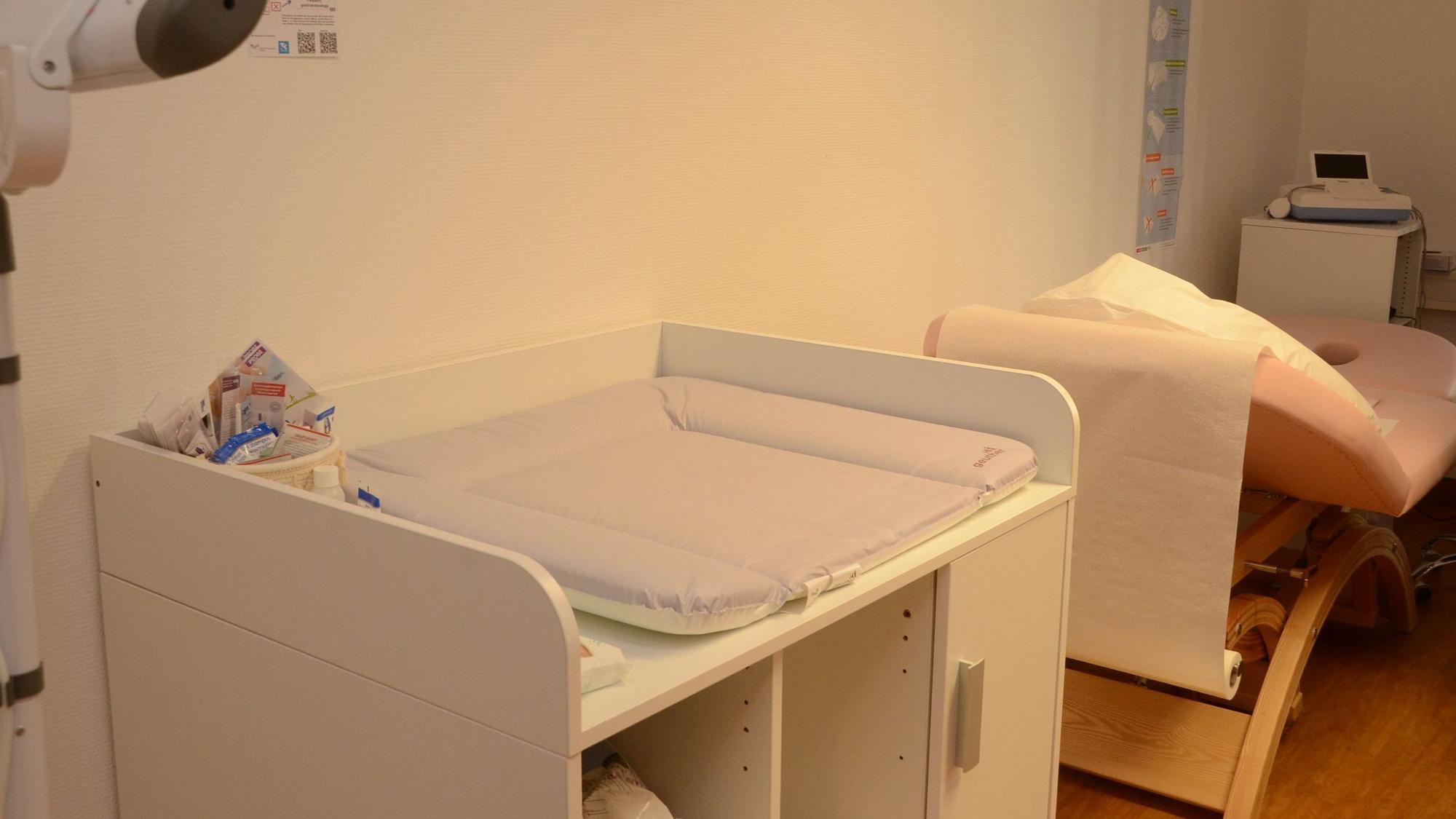 Zu sehen sind ein Wickeltisch und eine Untersuchungsliege im Untersuchungszimmer der Hebammenambulanz.