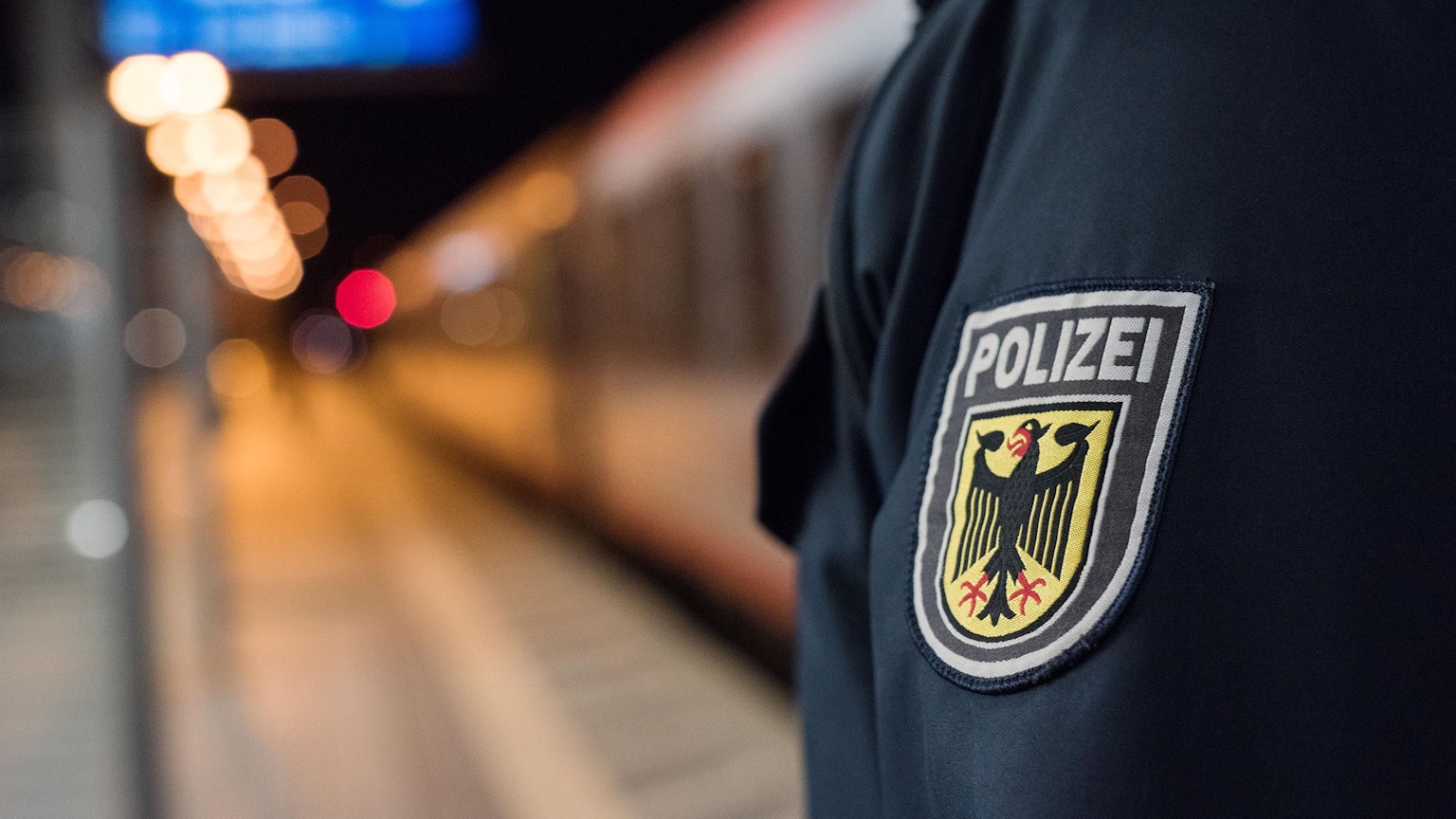 Ein Beamter der Bundespolizei steht an einem Bahnhof.