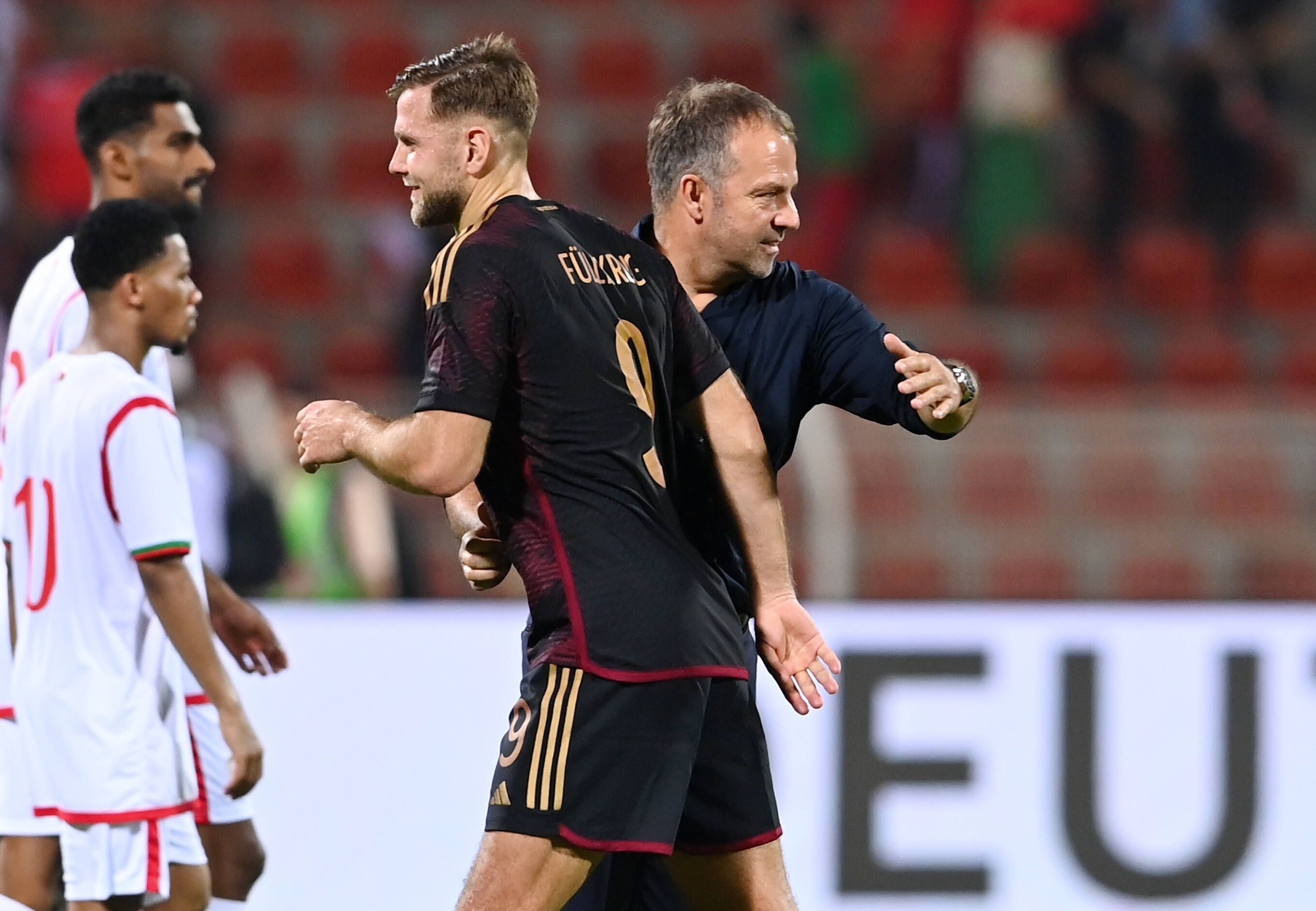 Bundestrainer Hansi Flick klatscht nach dem Spiel mit Torschütze Niklas Füllkrug ab.
