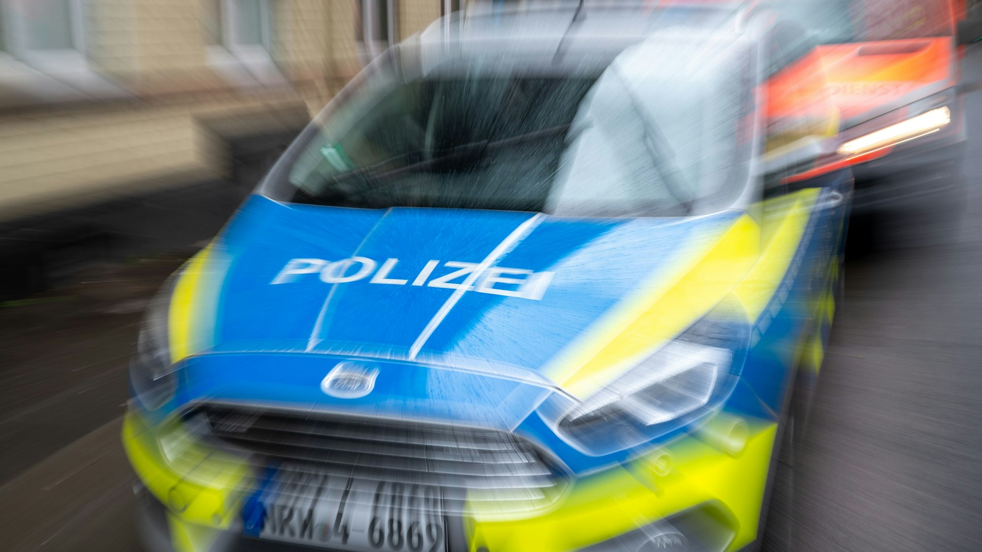 Ein blau-gelbes Einsatzfahrzeug der Köln Polizei. Das Bild ist verwackelt (Symbolbild)