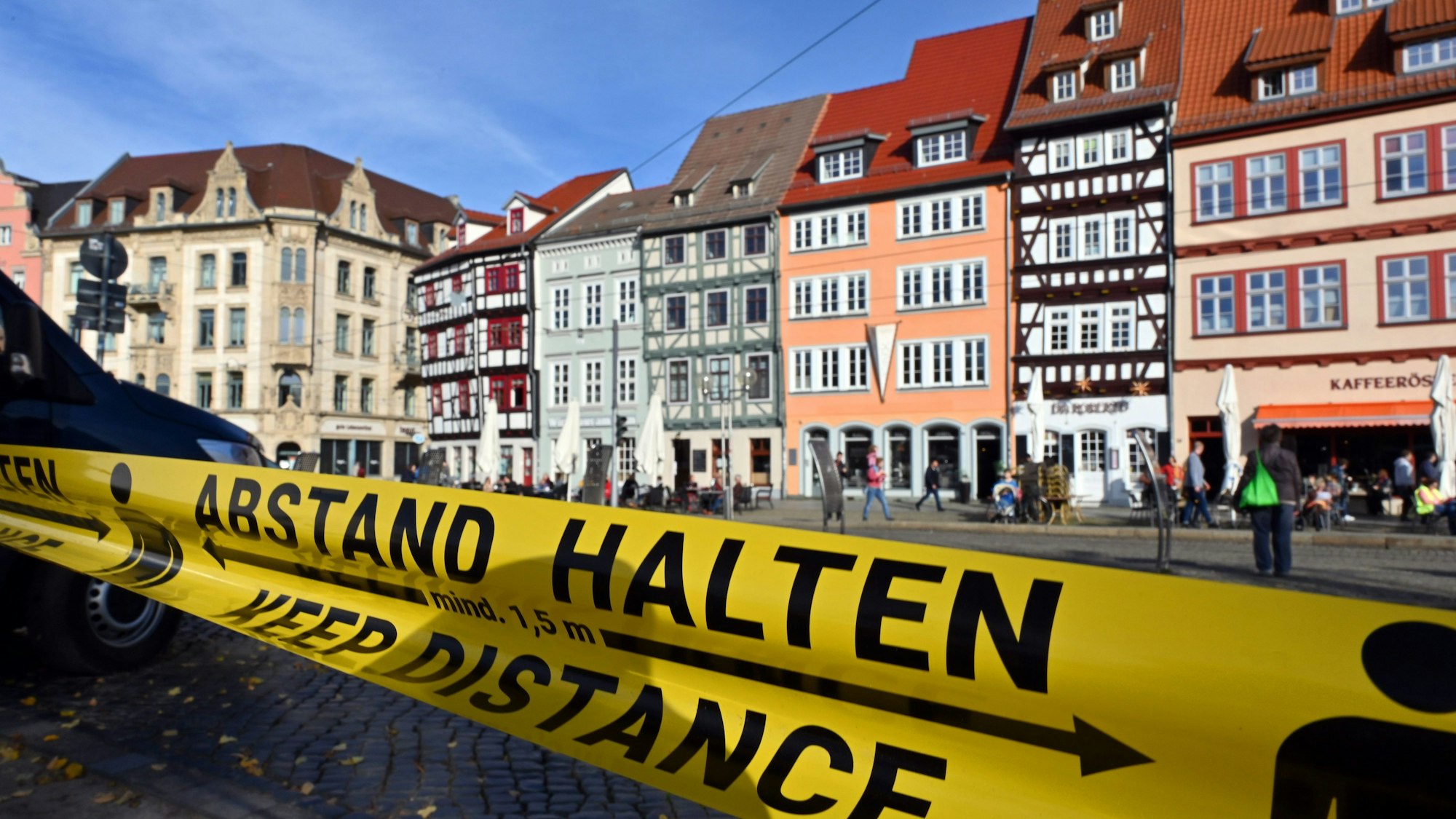 „Abstand halten!“ steht in deutscher und englischer Sprache auf einem Flatterband.