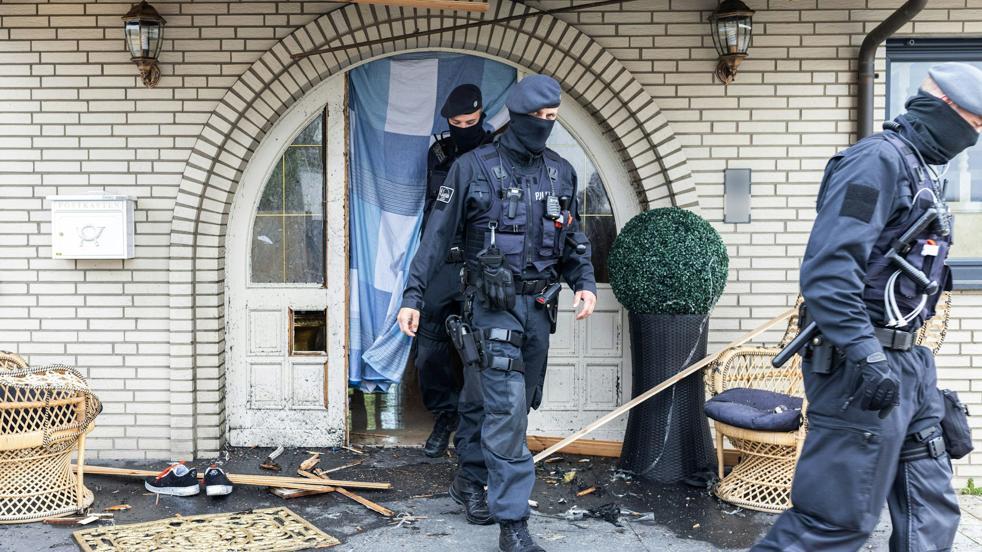 Polizisten verlassen in Leverkusen eine Villa nach Durchsuchungen im Bereich der Clankriminalität in Nordrhein-Westfalen.