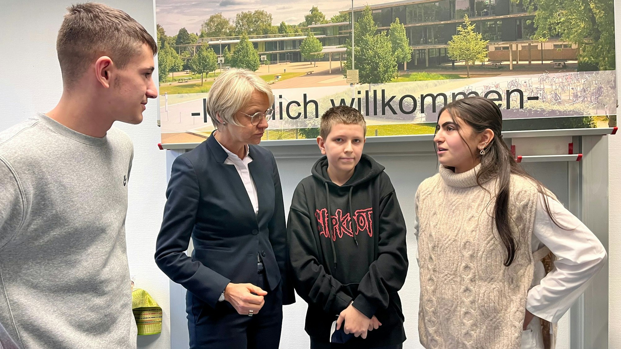 Drei Schüler sprechen mit Schulministerin Dorothee Feller.