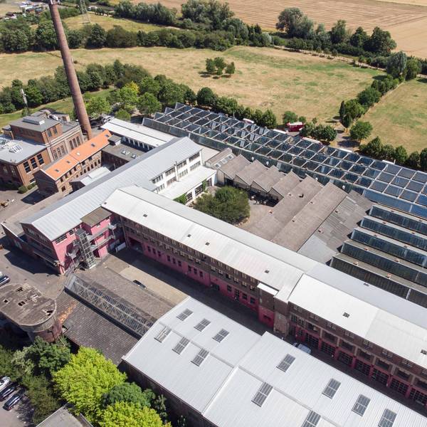 Auf dem alten Industriegelände stehen verschiedene Gebäude. Ein Großteil der Dächer ist mit Photovoltaik-Anlagen ausgestattet.