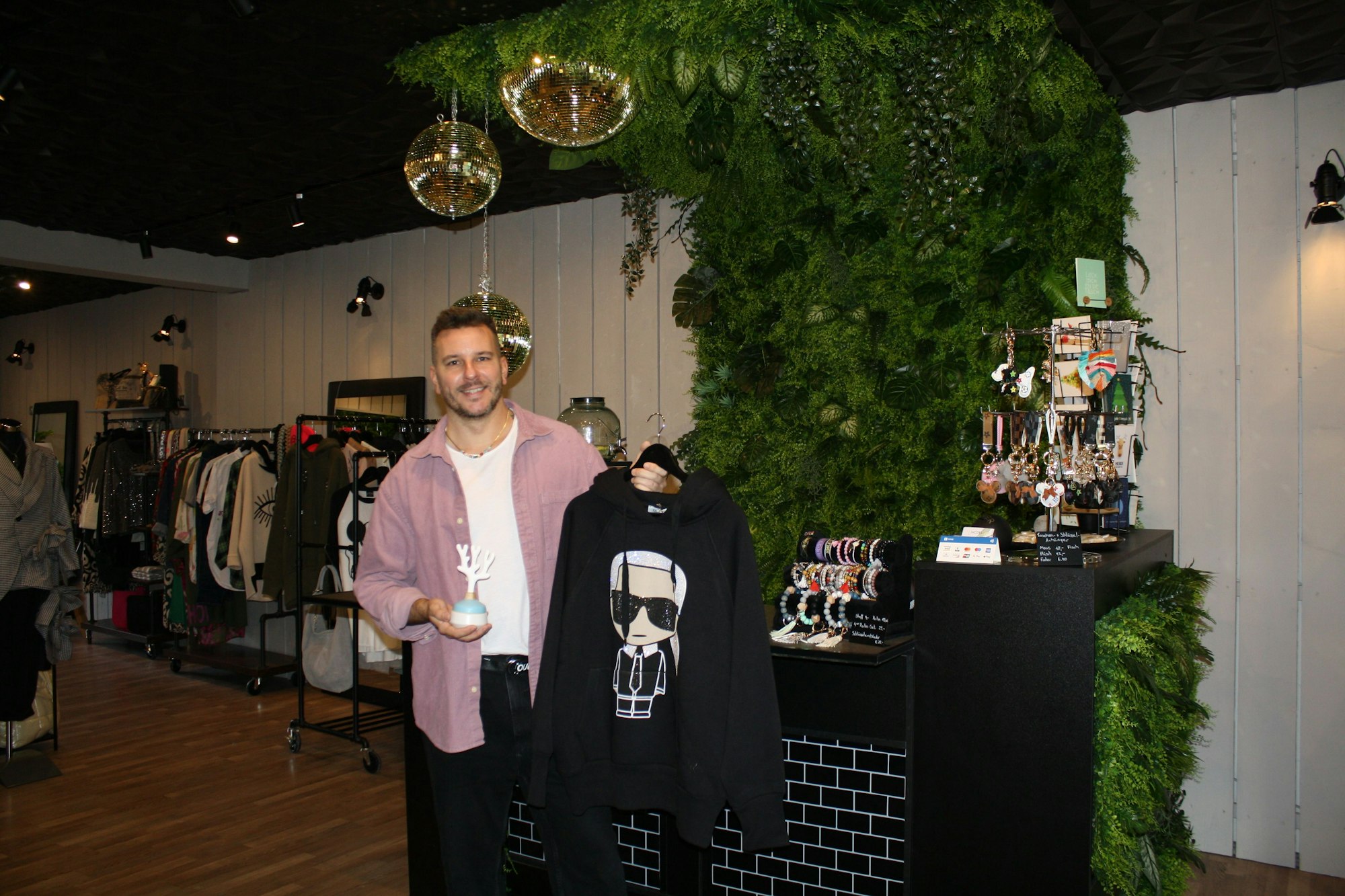 Oliver Jacobs mit einem schwarzen Pullover in der Hand