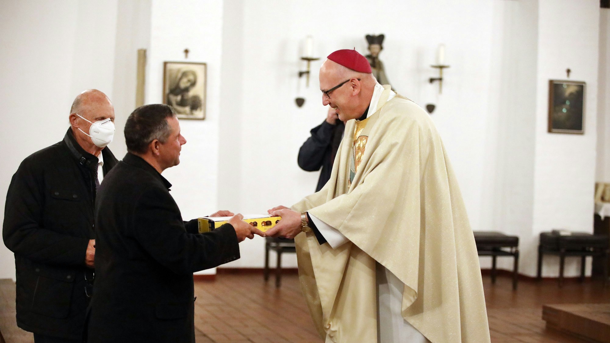 Weihbischof Radoslaw Zmitrowicz überreicht Ulrich Gürster und Norbert Kuhl Dankurkunden für ihre Hilfskonvois in die Ukraine.