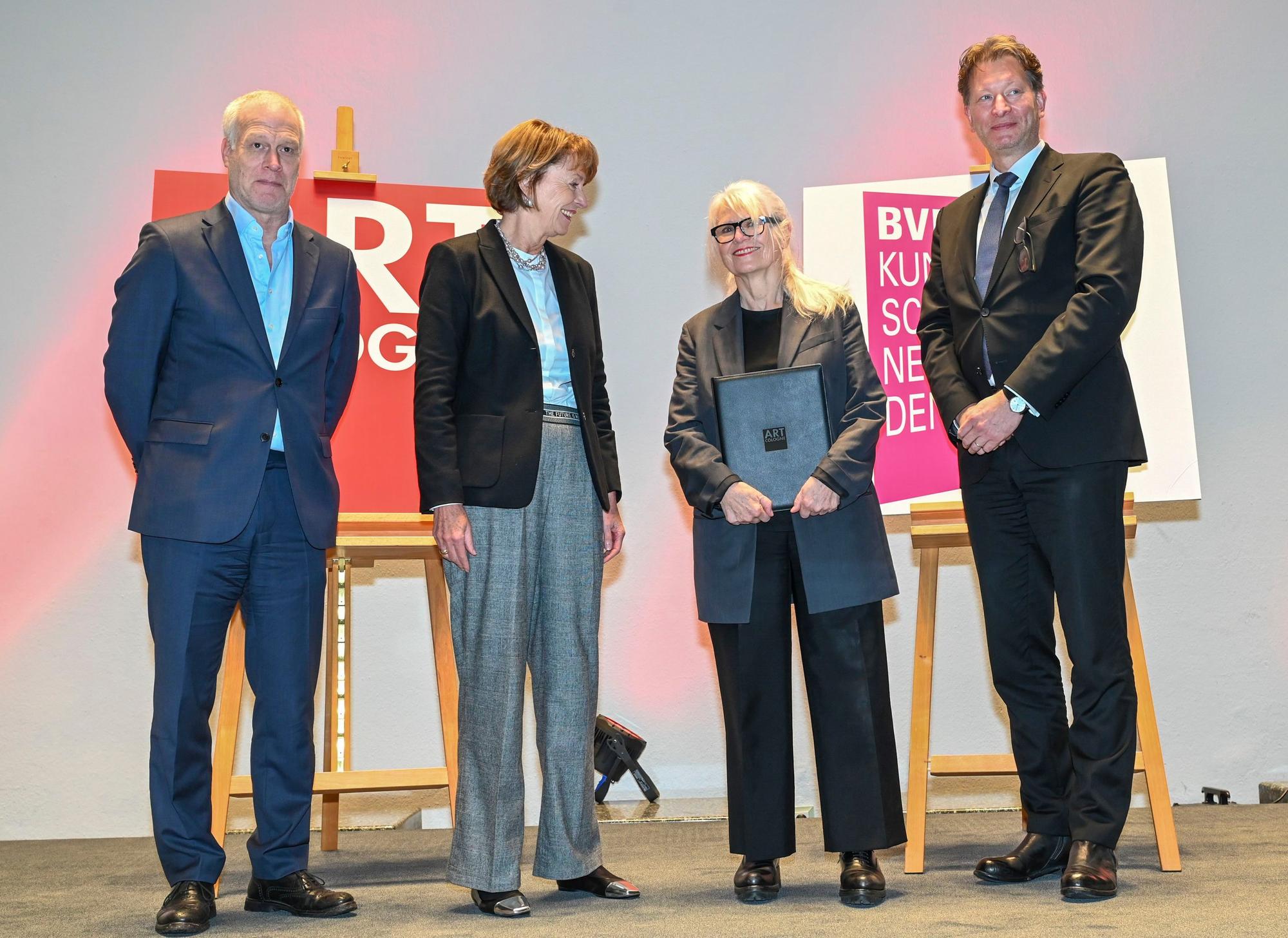 Monika Sprüth steht bei der Preisverleihung auf der Bühne des Historischen Rathauses in Köln. Sie wird eingerahmt von Art-Cologne-Chef Daniel Hug, Henriette Reker, Oberbürgermeisterin der Stadt Köln, und Kristian Jarmuschek, Vorsitzender des Bundesverbands Deutscher Galeristen