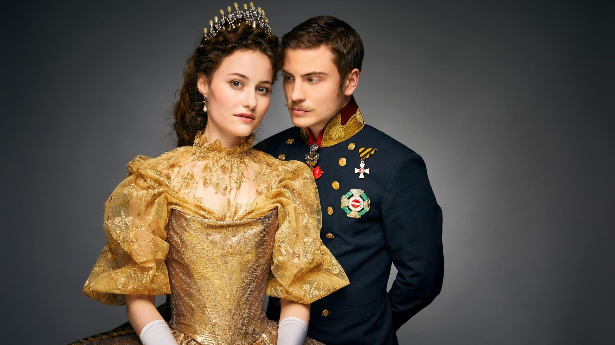 Dominique Devenport als Sisi und Jannik Schümann als Franz. Sie trägt ein goldenes Kleid, er eine dunkelblaue Uniform.