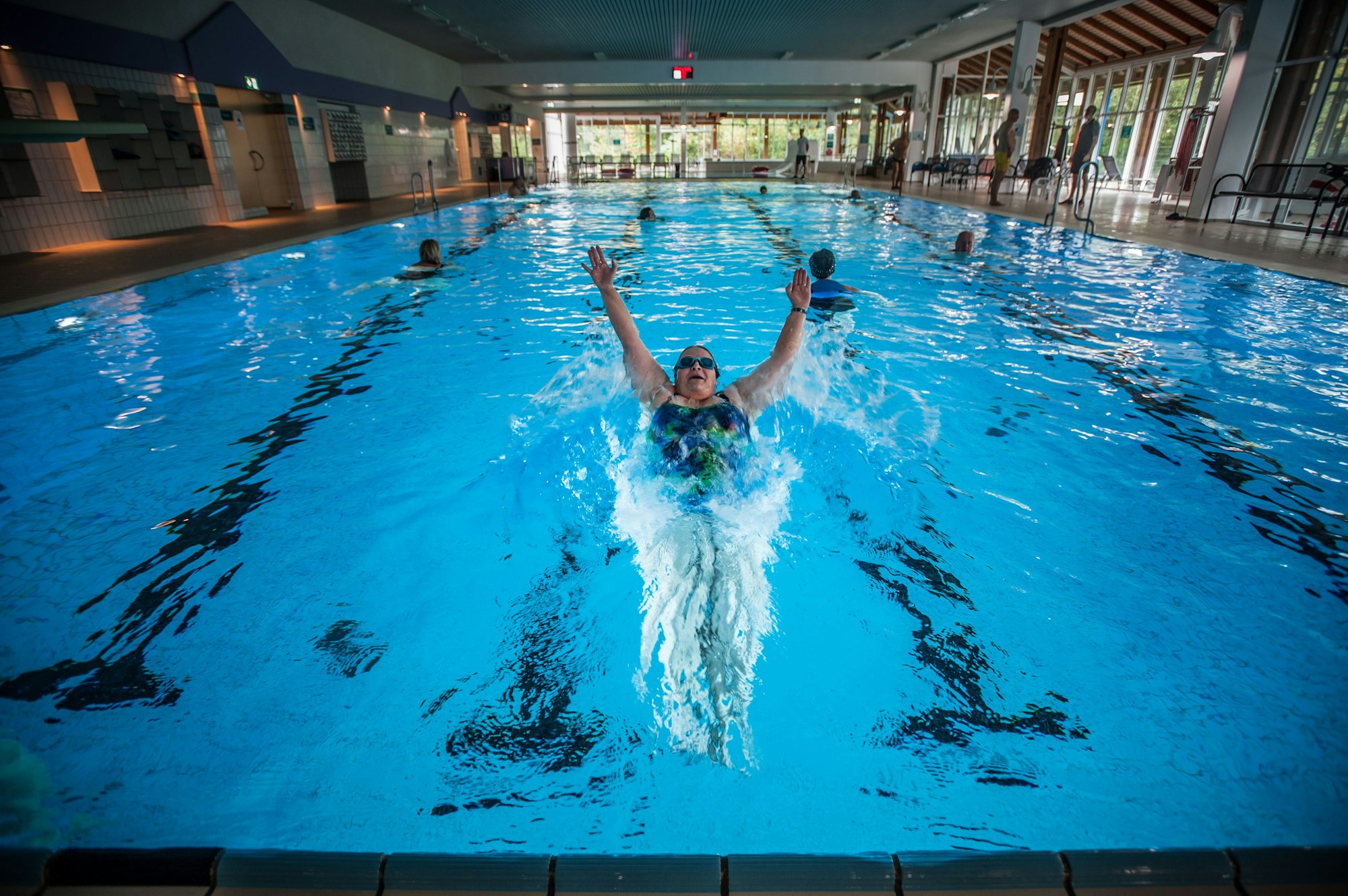 Eine Frau schwimmt im Innenbecken des Vitalbads Burscheid, weitere Schwimmer sind im Wasser.