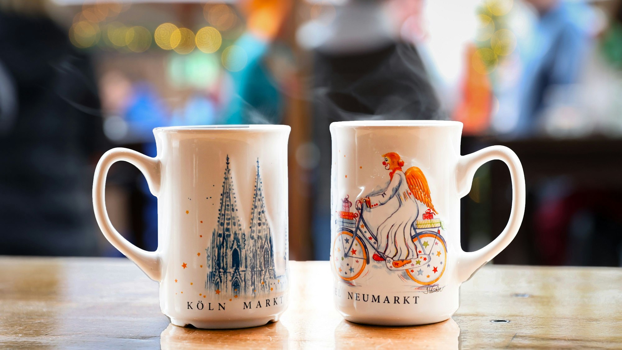 Zwei Tassen mit Glühwein stehen auf einem Tisch auf dem Weihnachtsmarkt am Kölner Neumarkt.