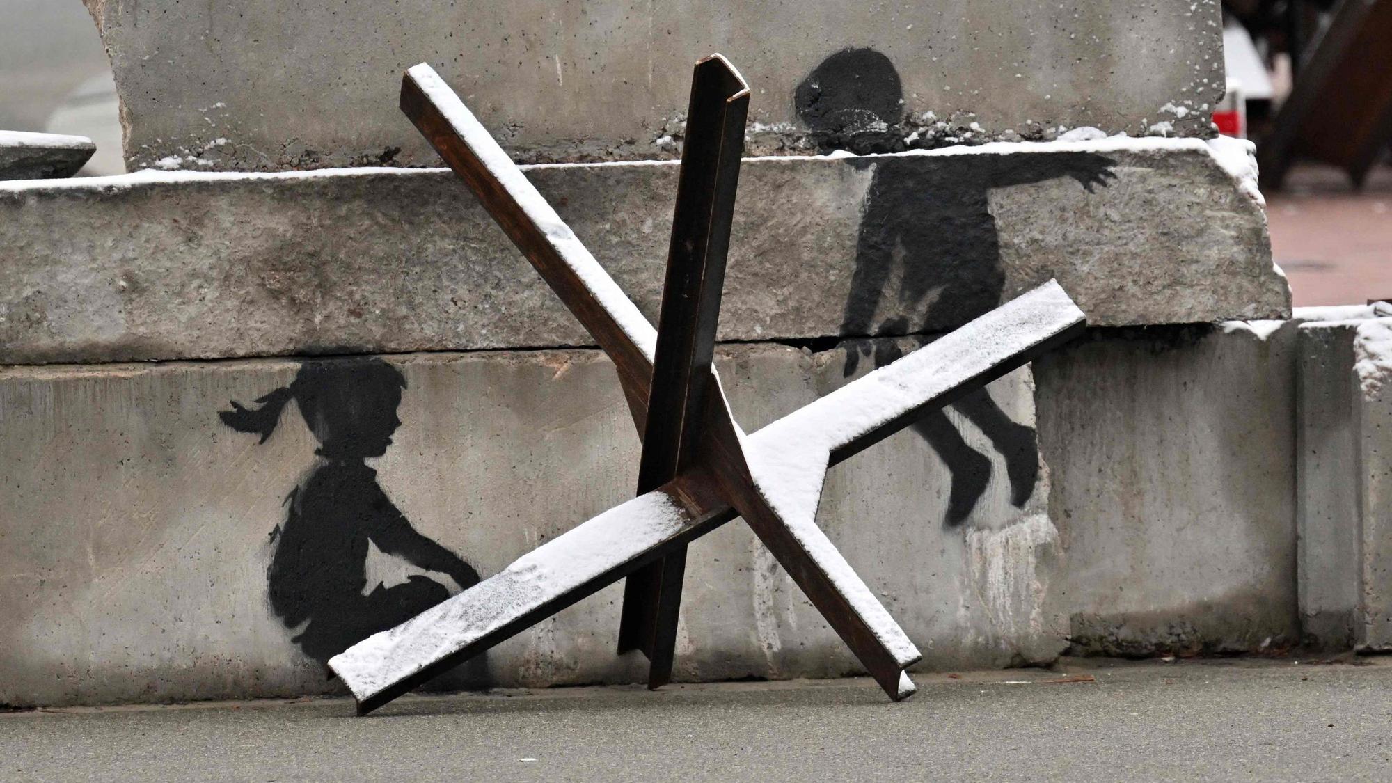 Auf einer Panzer-Barriere ist ein Werk von Banksy zu sehen.