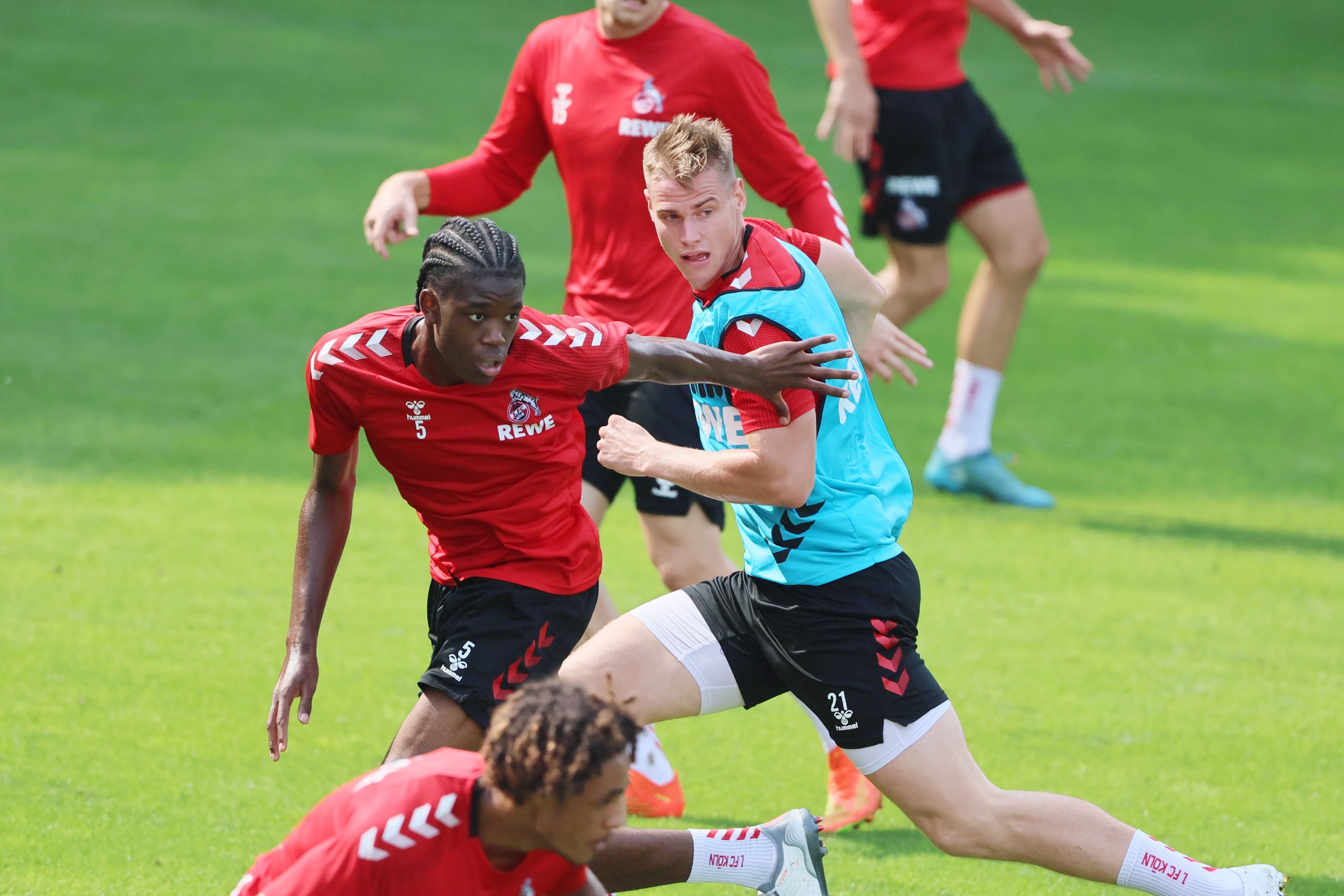 Fußballspieler befinden sich im Zweikampf. Der linke Spieler versucht, seinen Gegenspieler mit dem Arm wegzuschieben.