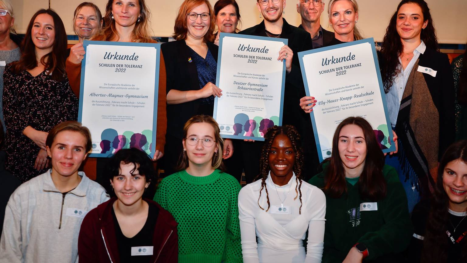 Vertreterinnen und Vertreter der Preisträger-Schulen halten die Urkunde des Toleranz-Preises in die Höhe.