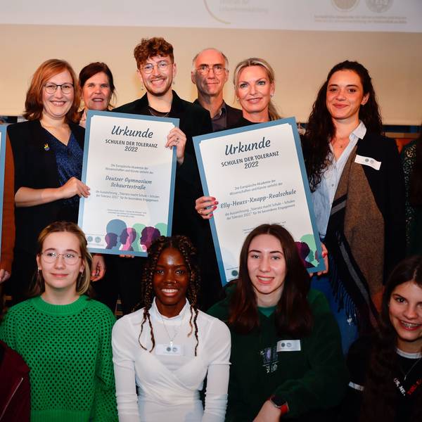 Vertreterinnen und Vertreter der Preisträger-Schulen halten die Urkunde des Toleranz-Preises in die Höhe.
