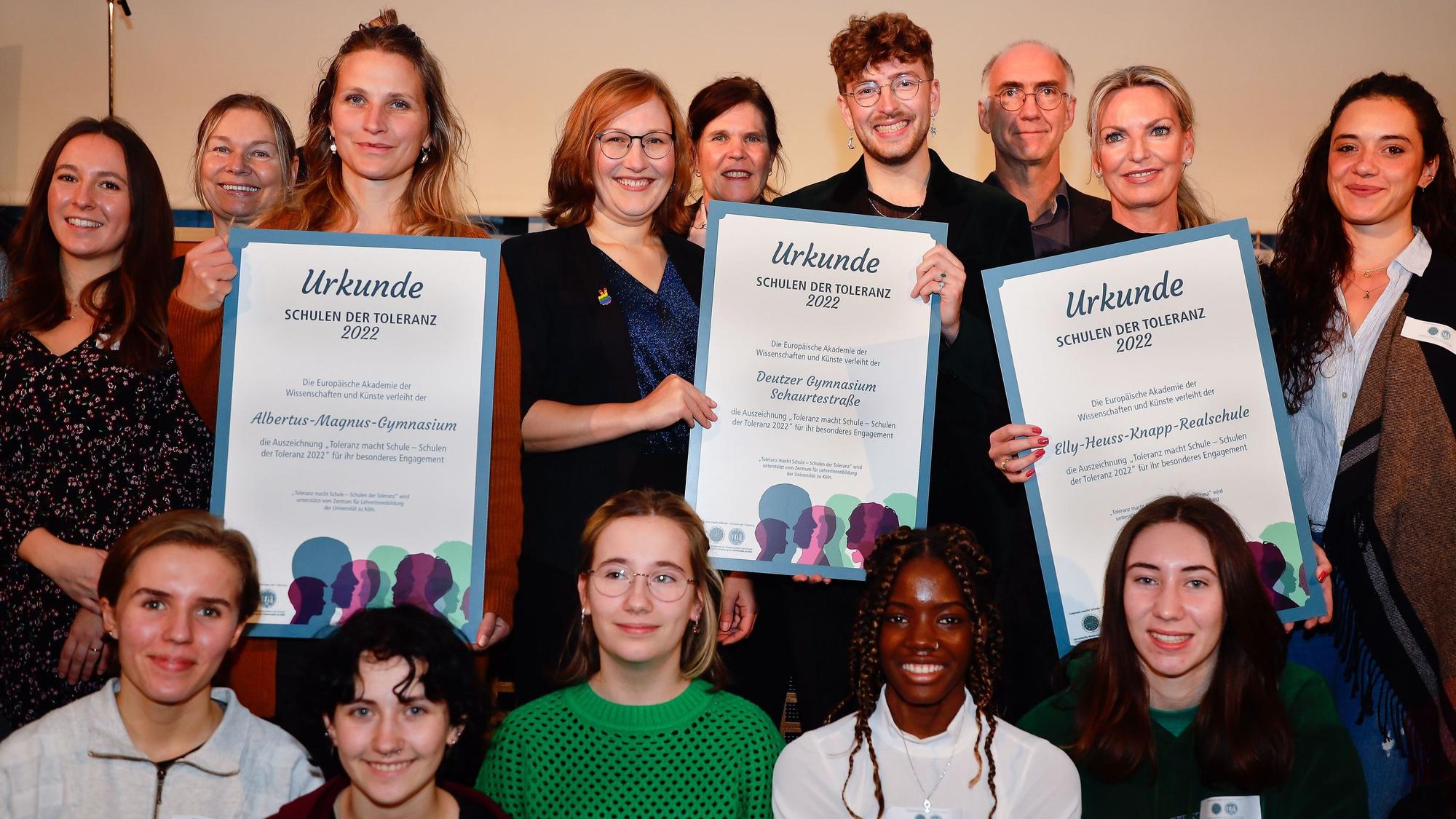 Vertreterinnen und Vertreter der Preisträger-Schulen halten die Urkunde des Toleranz-Preises in die Höhe.