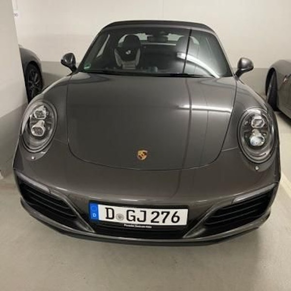 Ein Porsche Targa in grau-metallic ist auf einem Parkplatz in einer Tiefgarage geparkt.