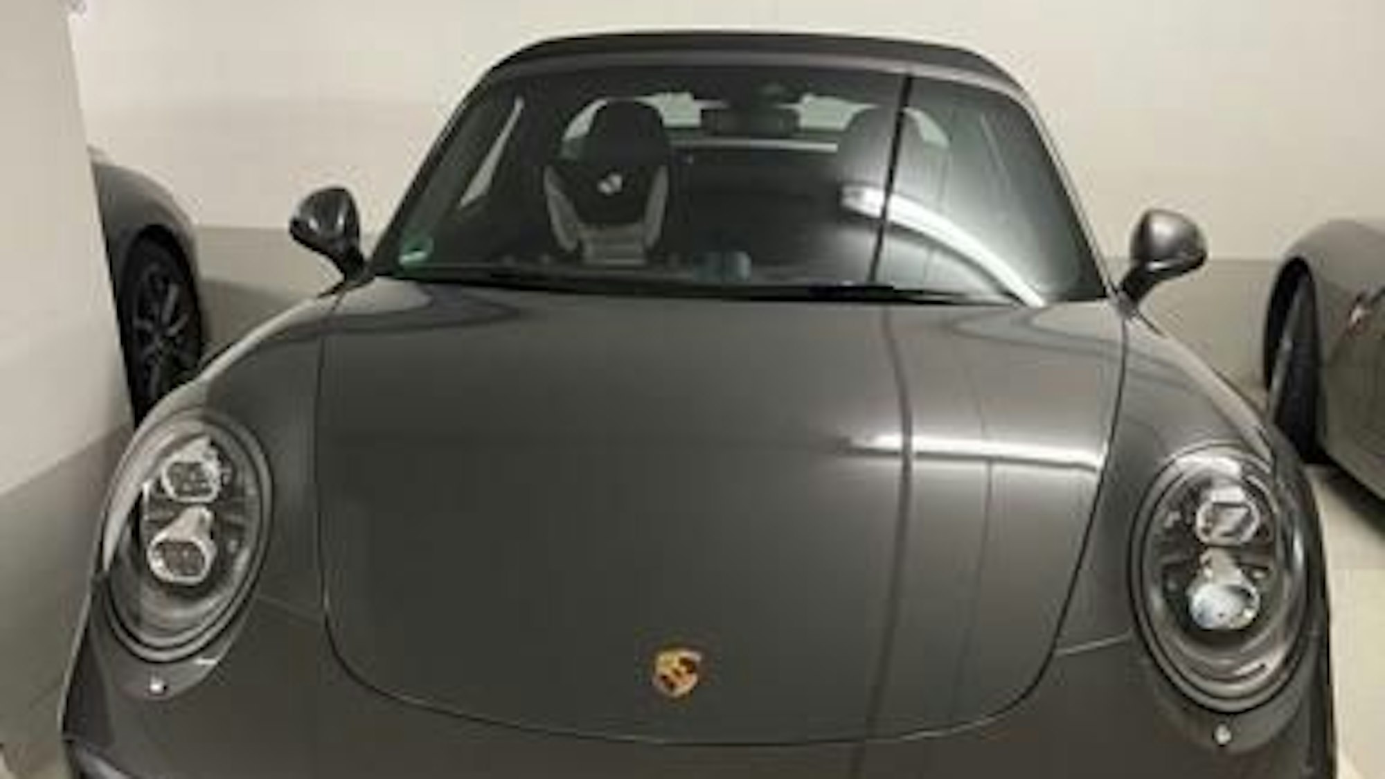Ein Porsche Targa in grau-metallic ist auf einem Parkplatz in einer Tiefgarage geparkt.