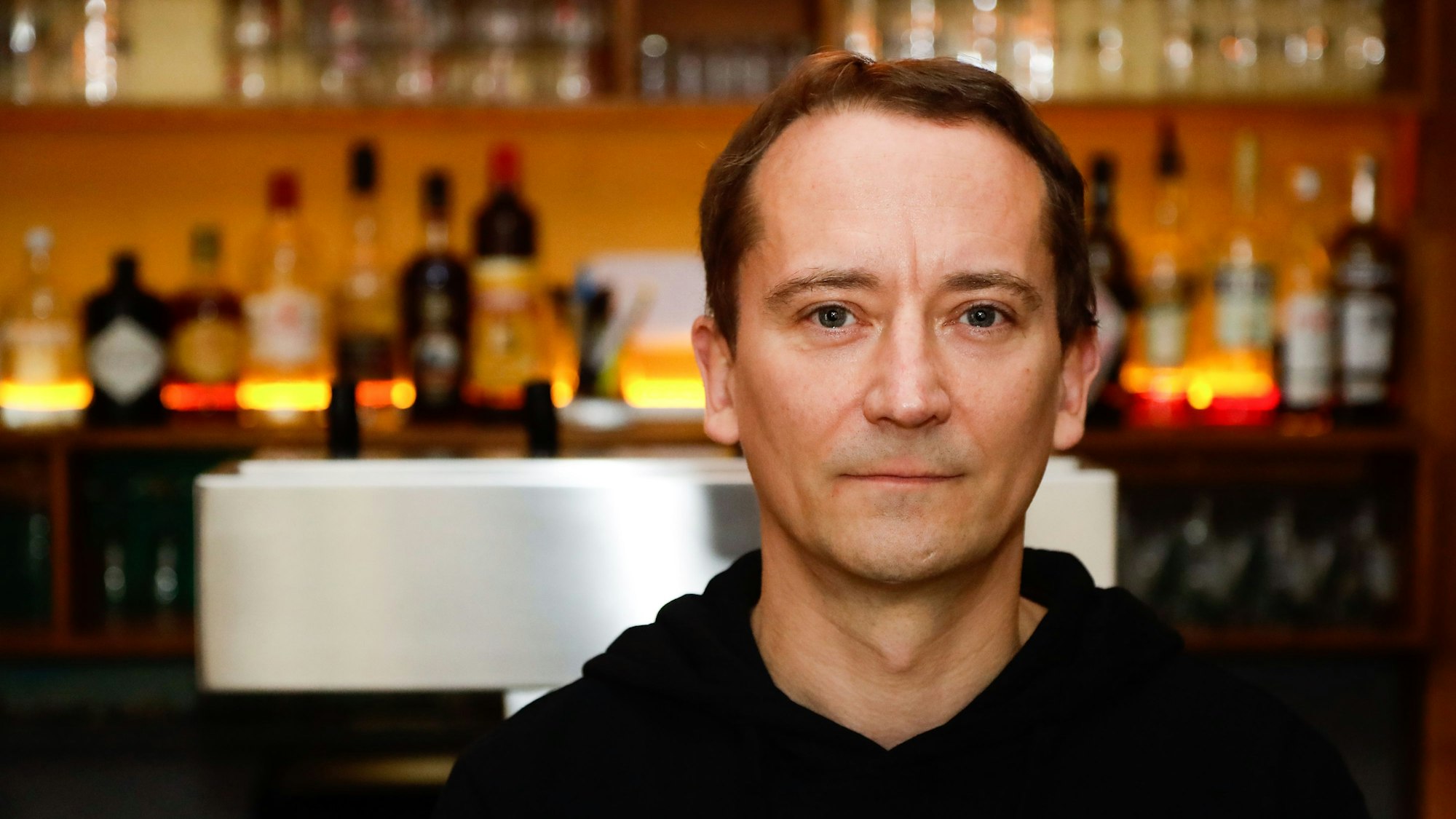 Wirt Petter Ritter von der Kneipe "Gottes Grüne Wiese" in der Kölner Bismarckstraße steht vor der Bar und blickt in die Kamera. Er boykottiert die WM 2022 und zeigt keine Spiele in seiner Gaststätte.