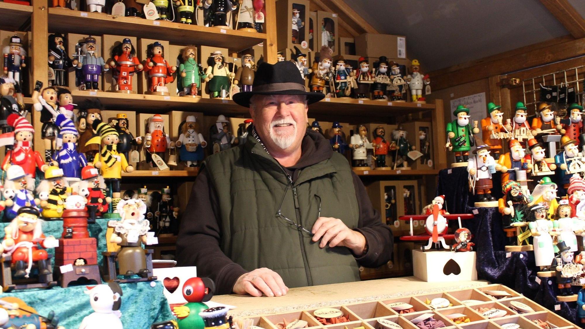 Verkäufer Wolfgang Schulder steht in seiner Bude zwischen Räuchermännchen, Krippenfiguren und Schneekugeln.