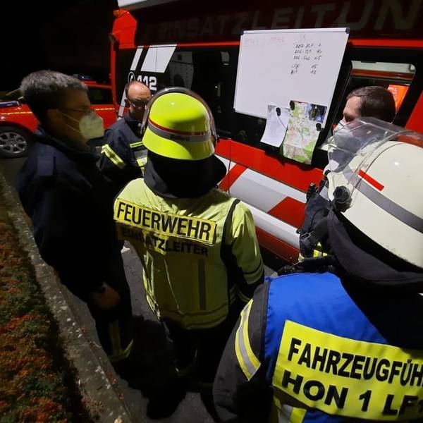 Bombenentschärfung in Bad Honnef. Feuerwehr steht vor Einsatzfahrzeug und bespricht sich.