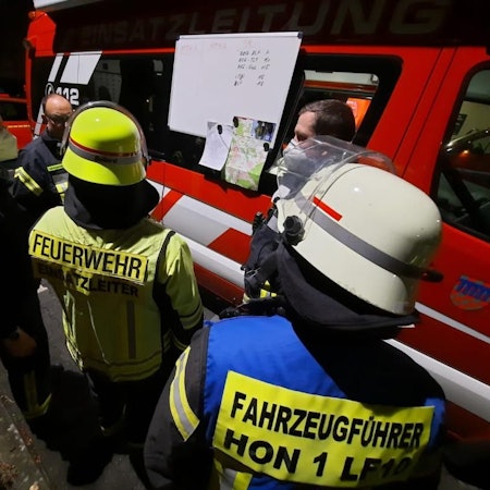 Bombenentschärfung in Bad Honnef. Feuerwehr steht vor Einsatzfahrzeug und bespricht sich.