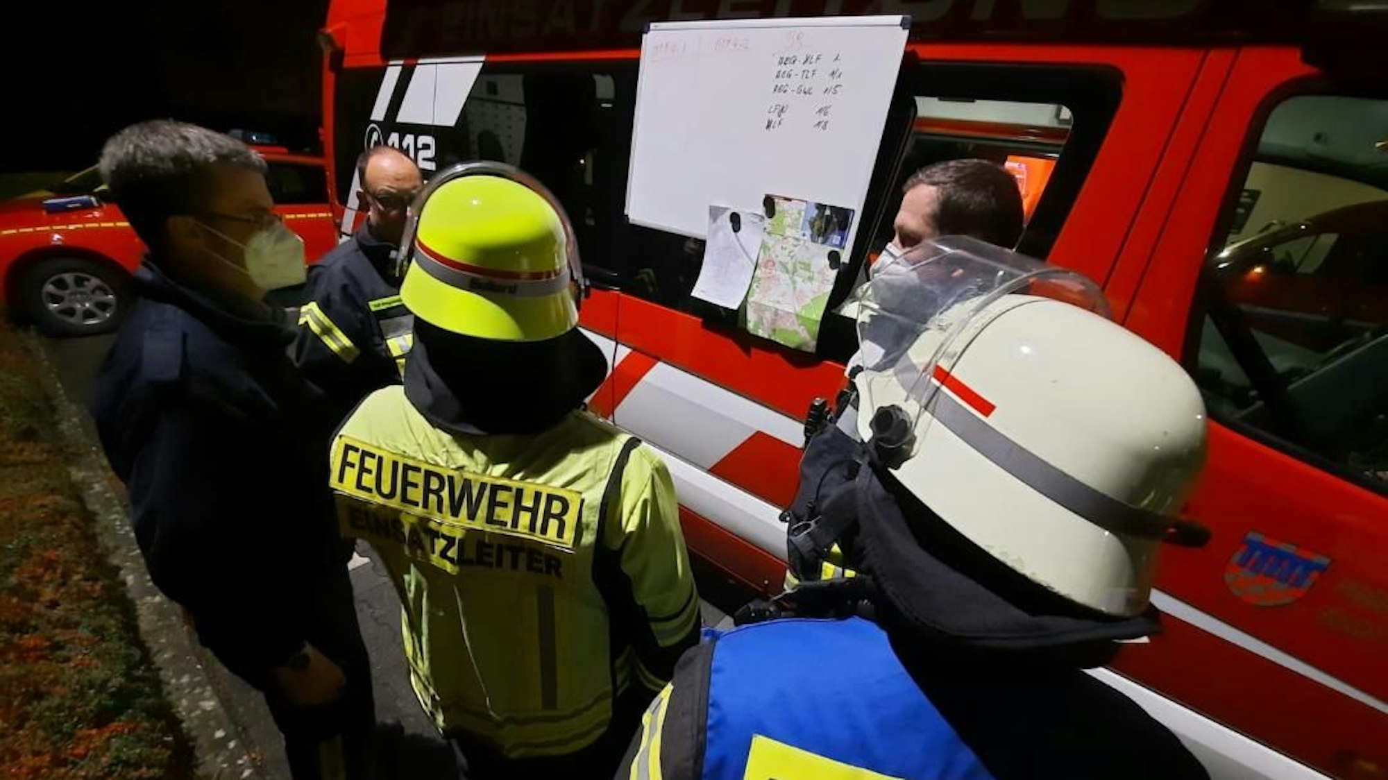 Bombenentschärfung in Bad Honnef. Feuerwehr steht vor Einsatzfahrzeug und bespricht sich.