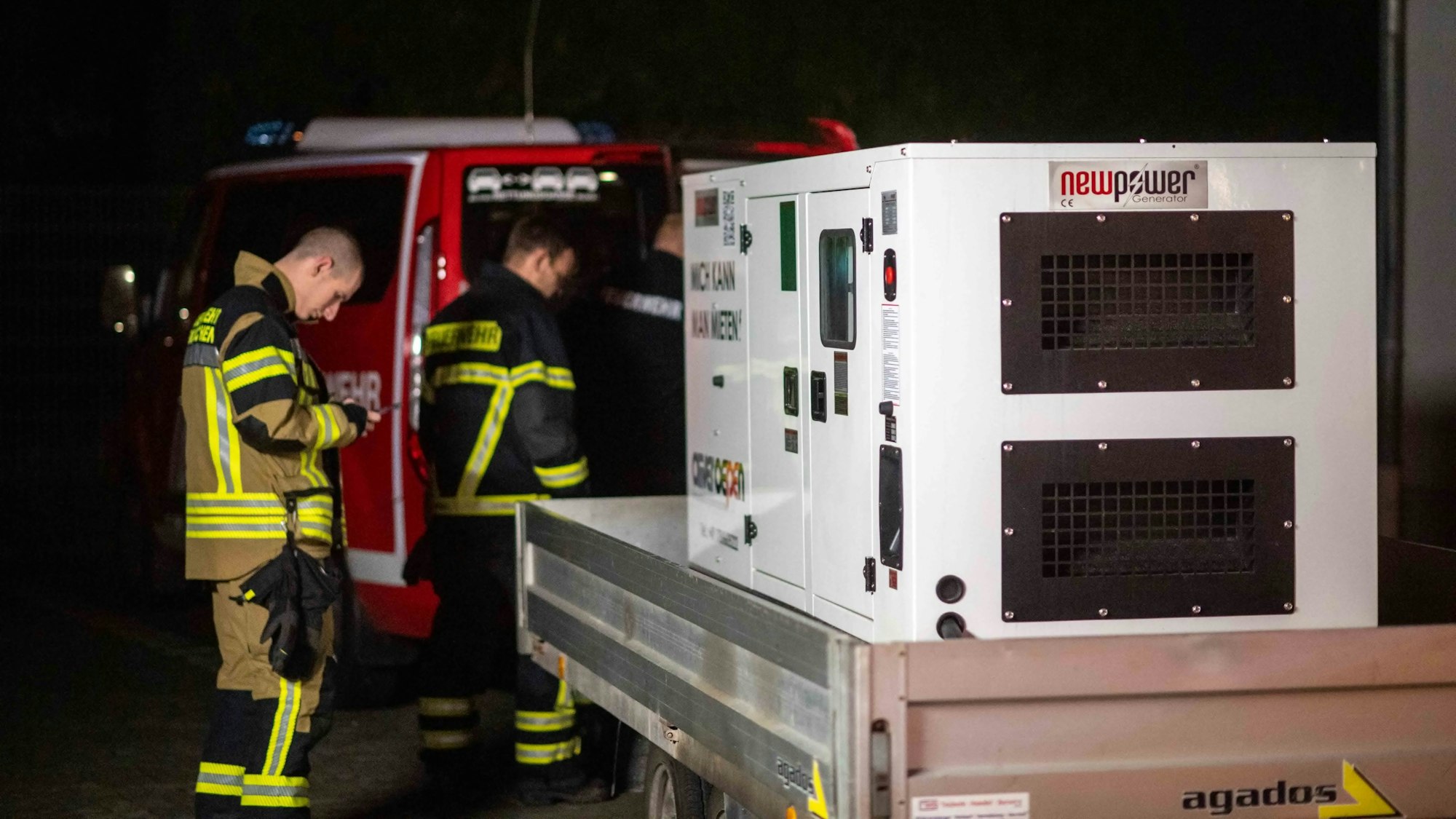 Zwei Feuerwehrmänner der Löschgruppe Stotzheim stehen vor einem Notstromaggregat.