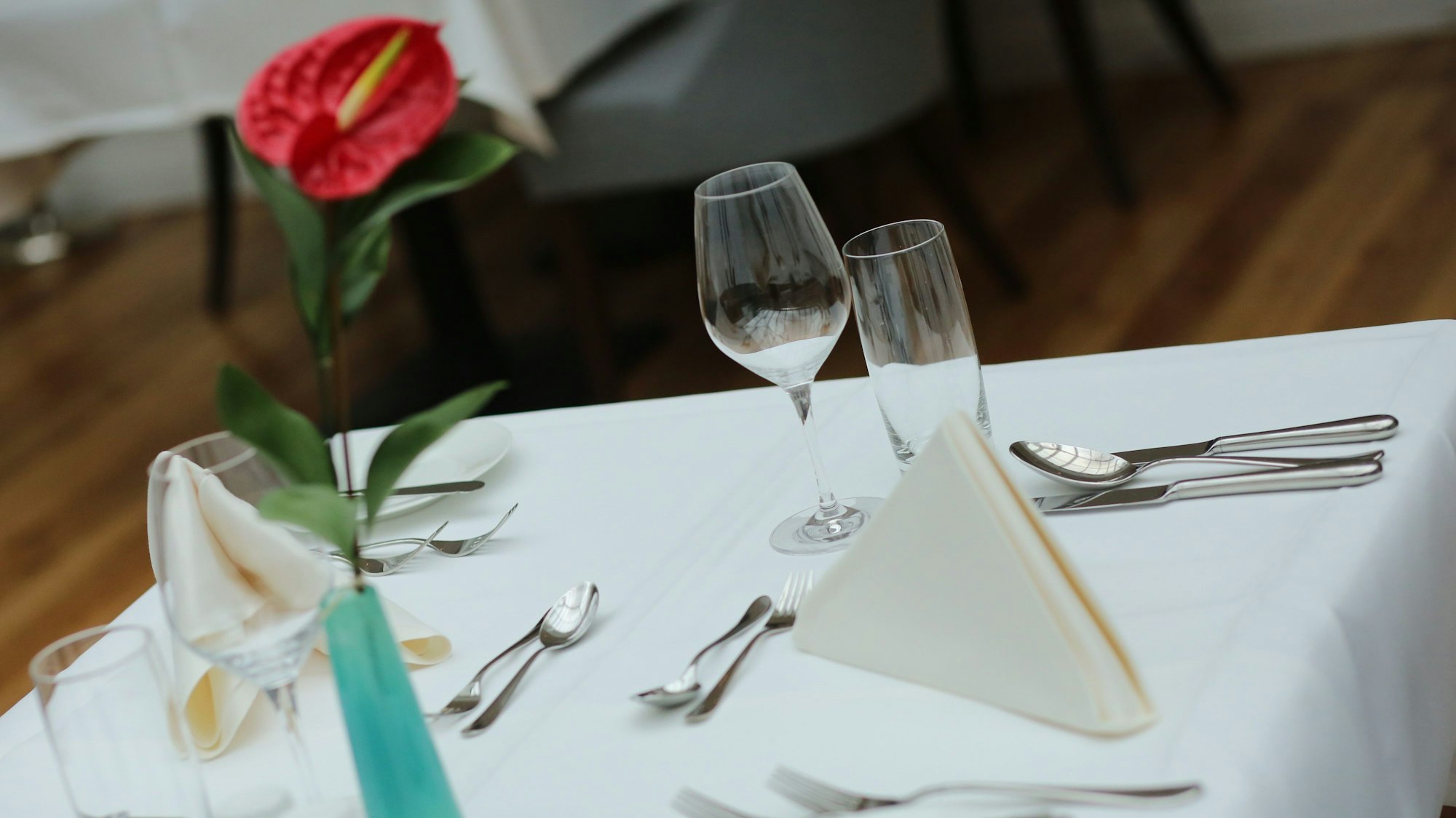 Ein eingedeckter Tisch wartet in einem Restaurant auf Gäste.