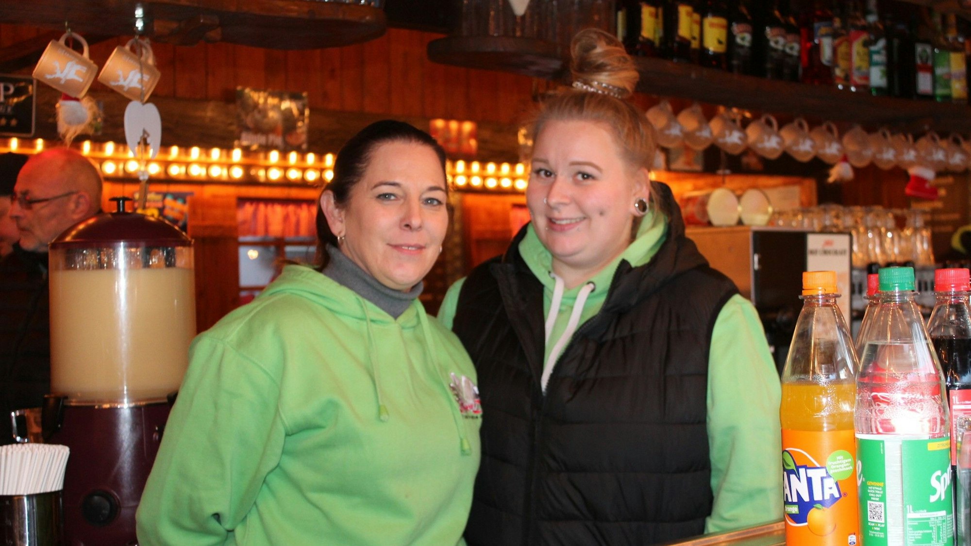 Die Glühweinverkäuferin Nadine Jackmuth steht neben einer Kollegin in der Verkaufsbude.
