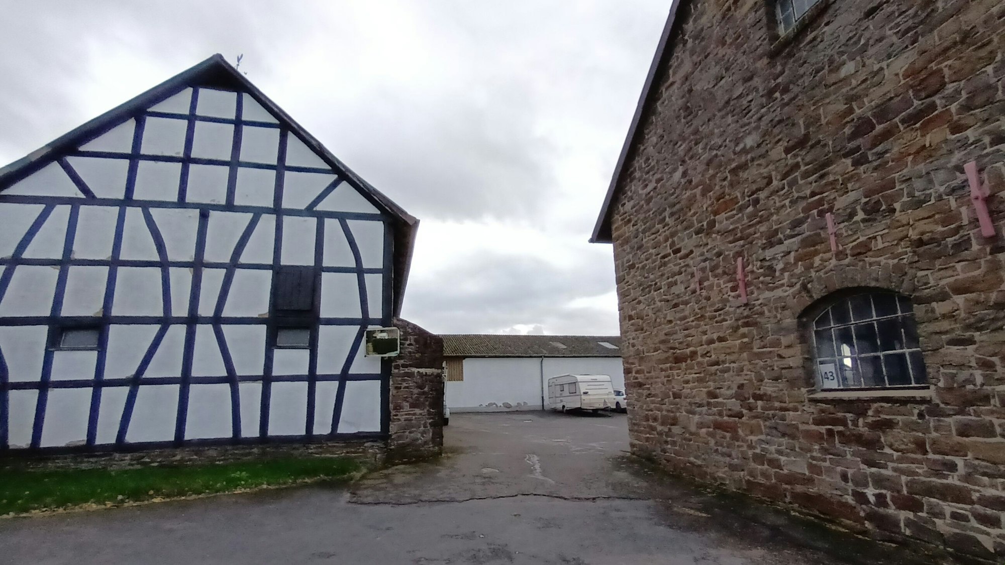 Auf dem Rittergut Haus Freiheit in Lohmar-Inger steht eine denkmalgeschützten Fachwerkscheune neben einer Bruchsteinscheune.