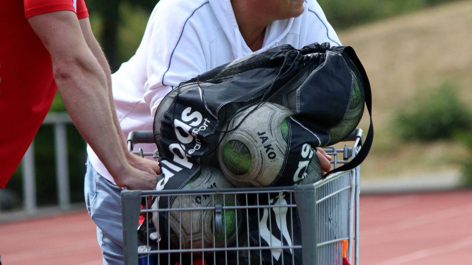 Der frühere ETSC-Trainer Hartmut Pitten lehnt beim Saisonauftakt gegen den SC Wißkirchen an einem Einkaufswagen, in dem die Ersatzbälle transportiert sind.