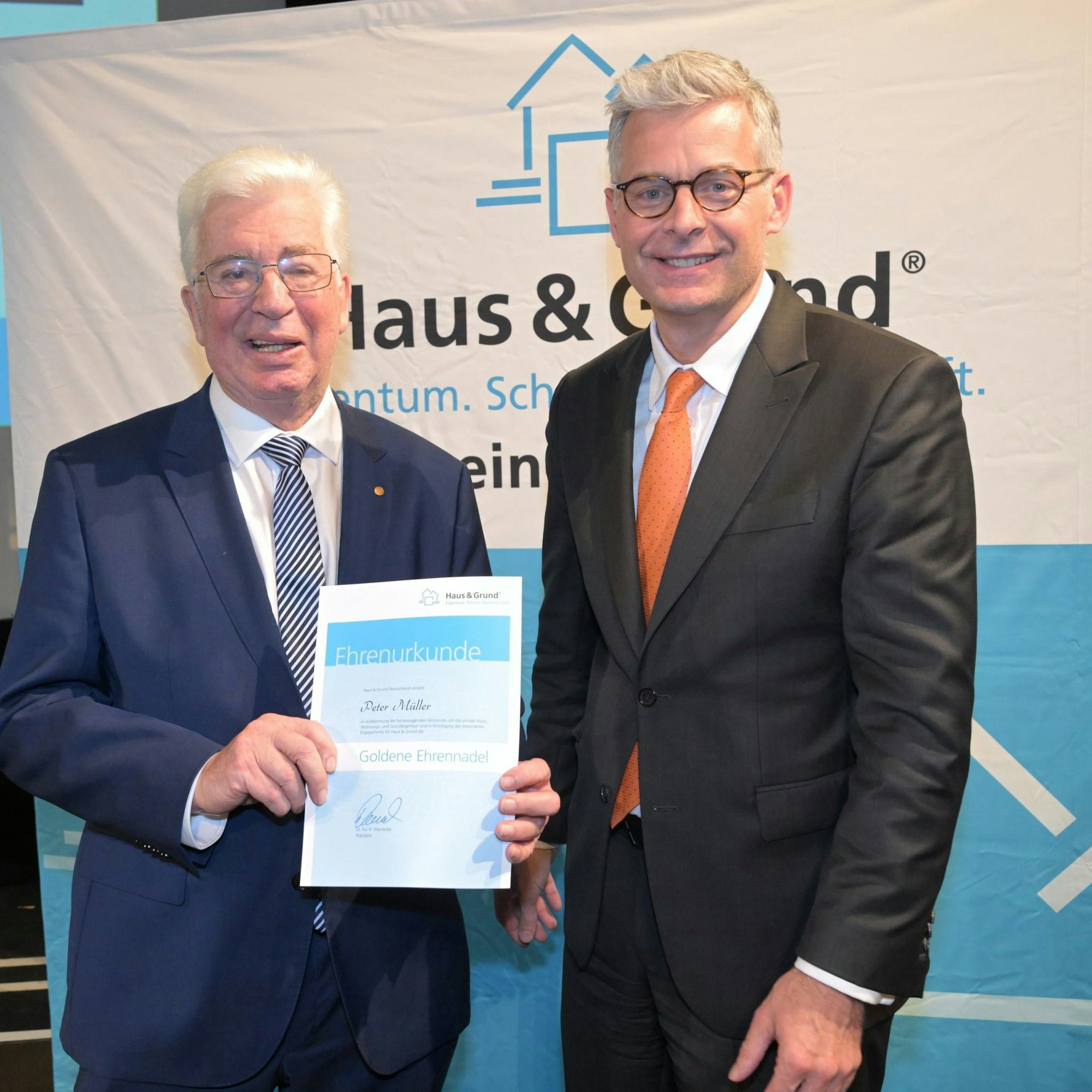 Der Vorsitzende von Haus und Grund Bergisch Gladbach, Peter Müller, hält eine Ehrenurkunde in der Hand, die Kai Warnecke, Bundespräsident von Haus und Grund, ihm überreicht hatte.